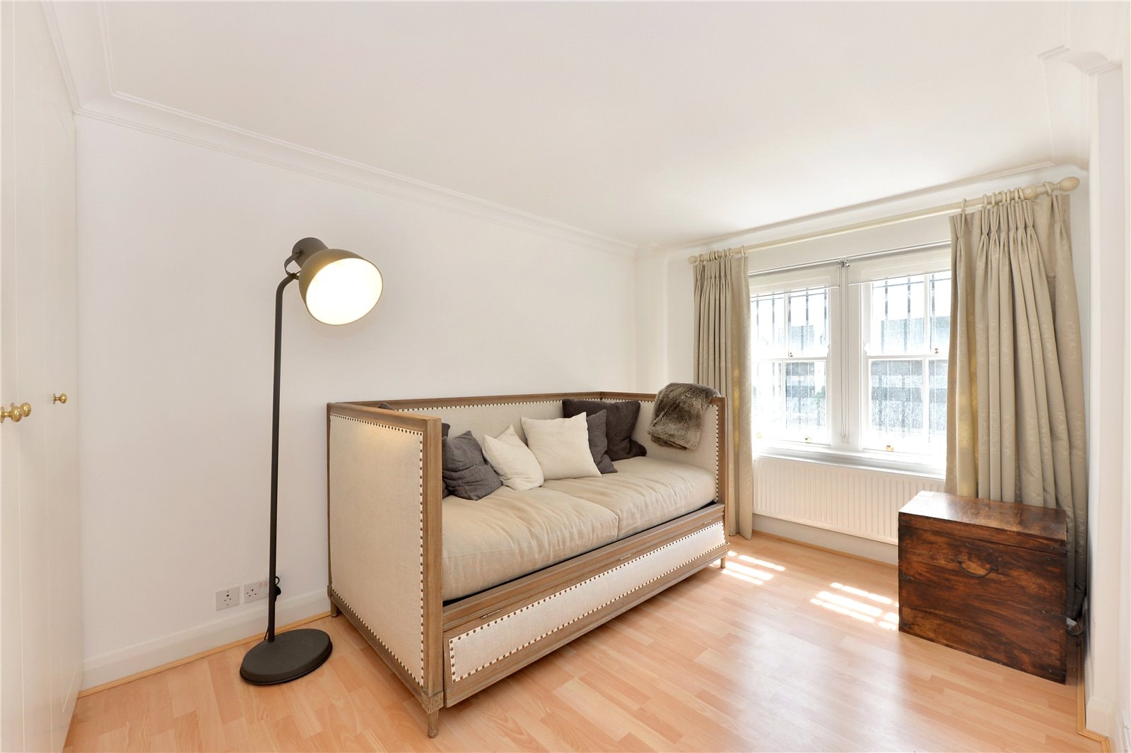 Elegant living room with vintage sofa and large windows, ideal for London property interiors.