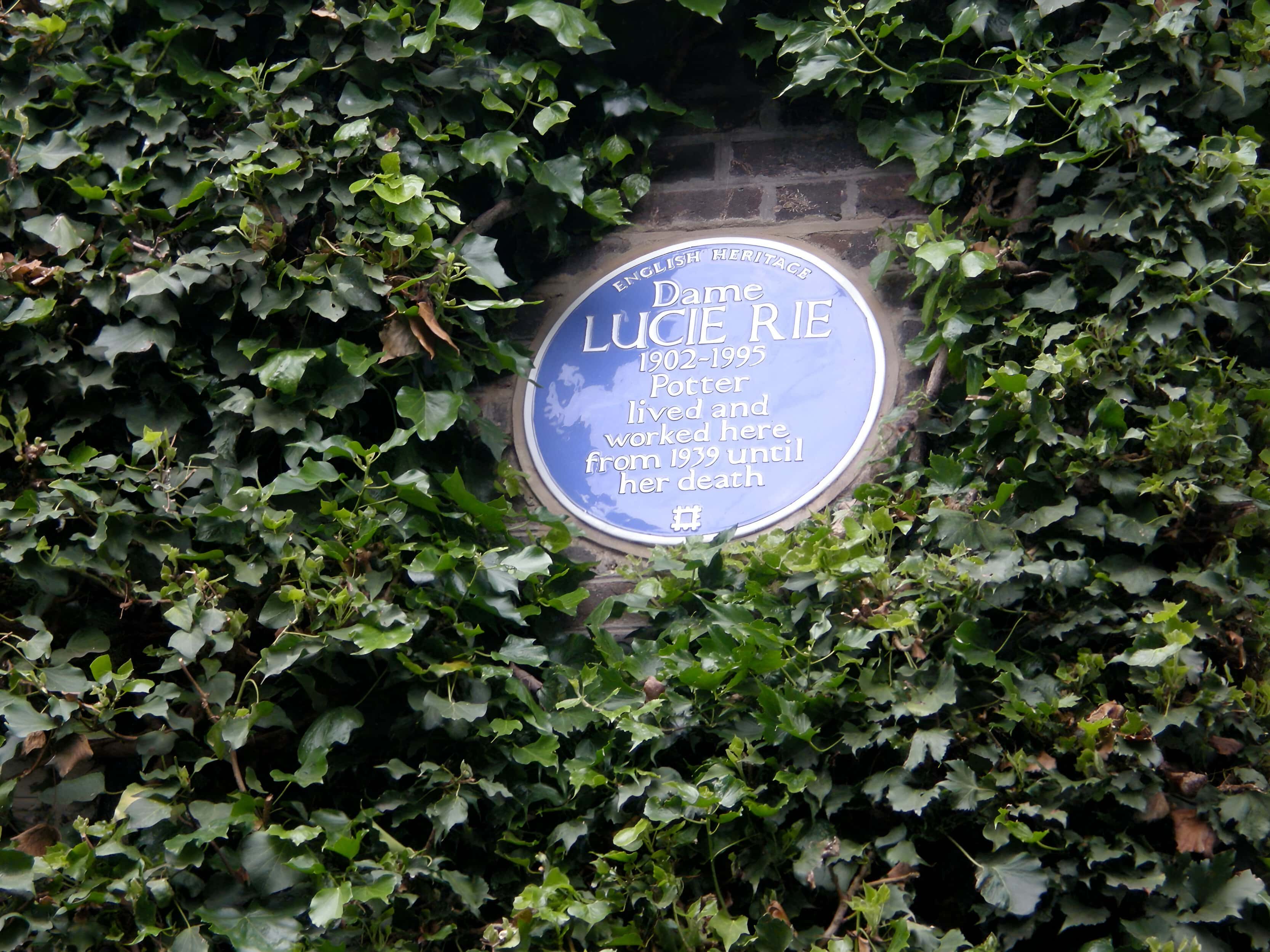 Blue plaque for Dame Lucie Rie in Bayswater, London, surrounded by ivy.