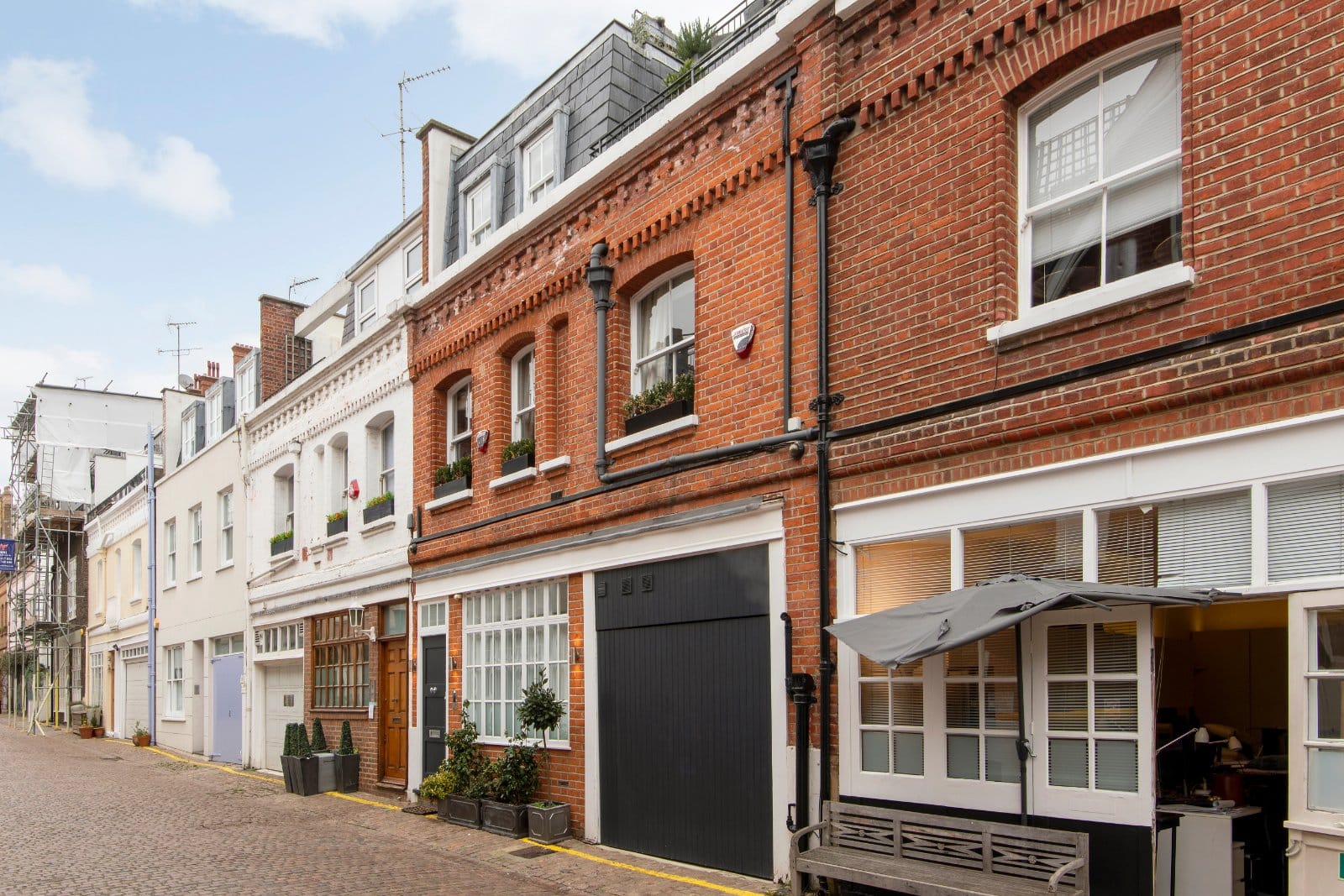 Charming Georgian and Victorian terraced houses on London street, showcasing classic brickwork and period architecture.