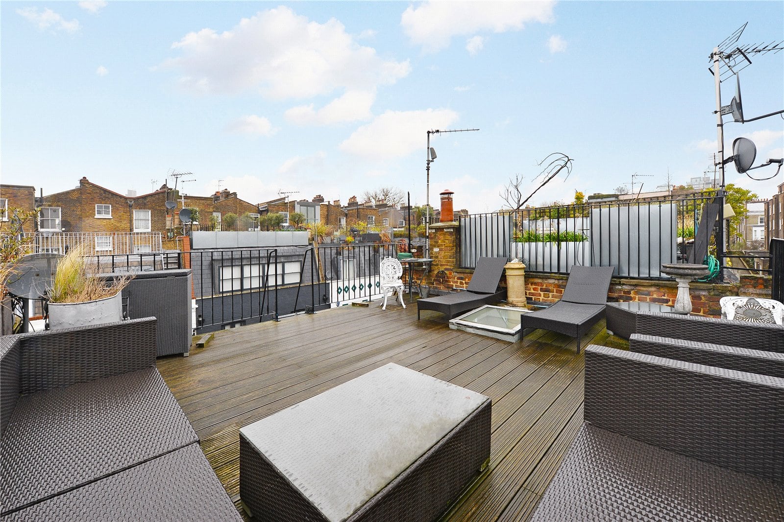 Spacious London rooftop terrace with outdoor furniture and city views.
