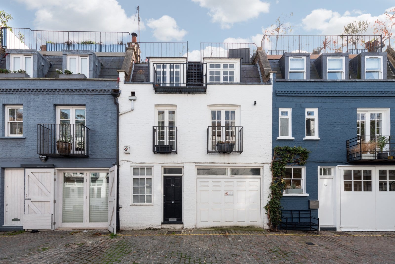 Brightly coloured terraced houses in London with charming balconies and classic architectural details.