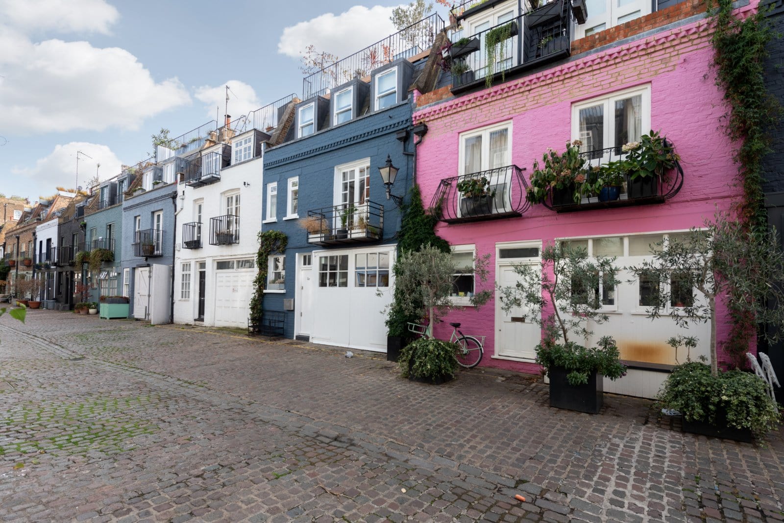 Colourful row of London terraced houses with vibrant facades and small balconies, characteristic of the city’s historic architecture.