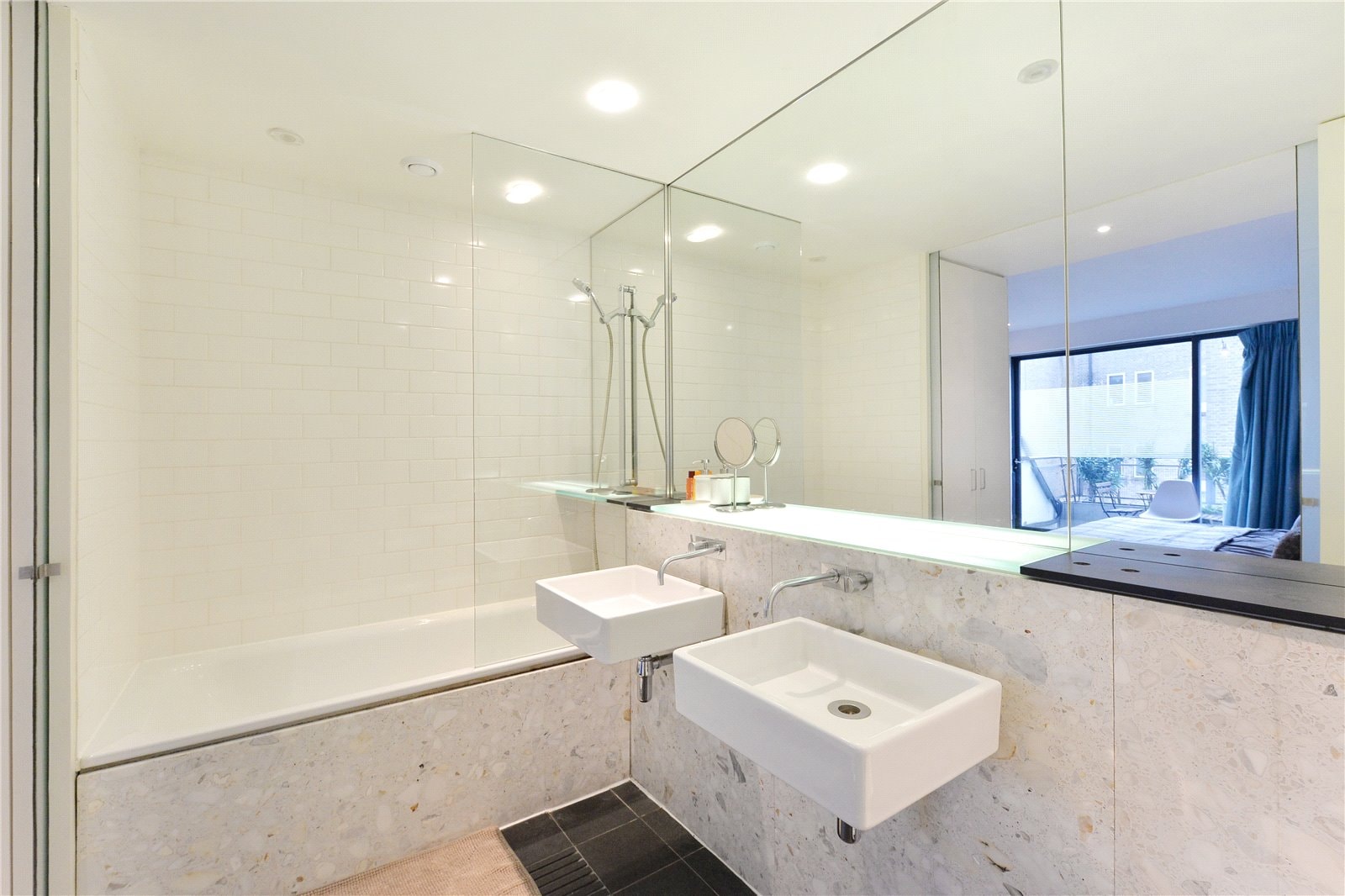 Contemporary bathroom with twin sinks, marble details, and large mirror, showcasing modern interior design.