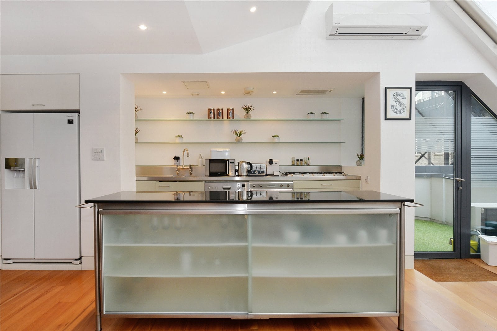 Bright modern kitchen with sleek appliances and open shelving. Perfect for contemporary London living.