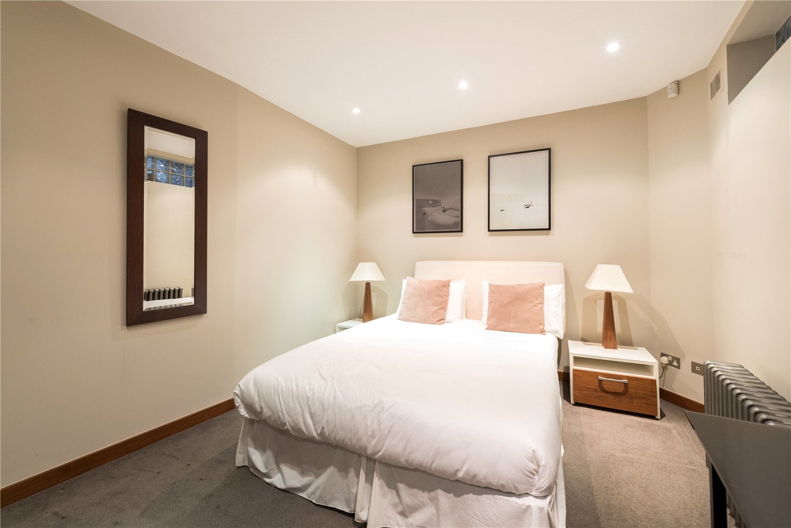 Modern bedroom with neutral decor and cosy lighting, perfect for luxury London accommodation.