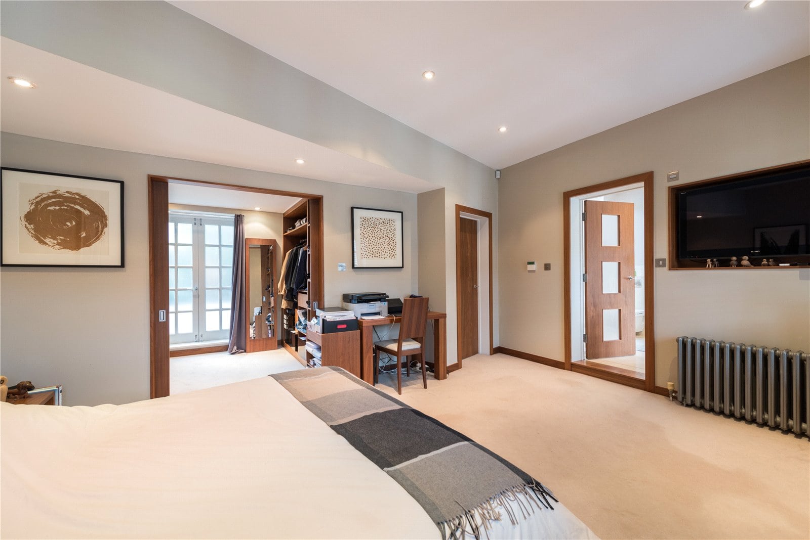 Spacious luxury bedroom featuring a walk-in wardrobe and modern decor at Lurot Brand property in London.