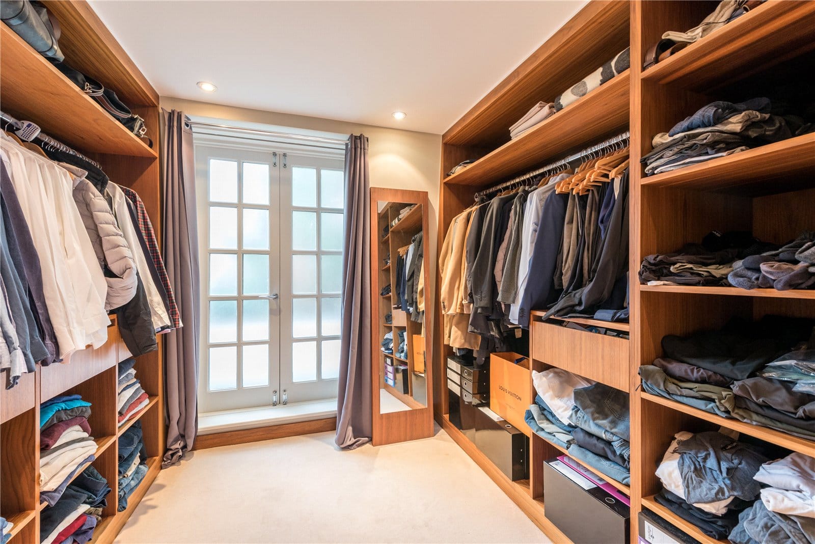 Luxurious walk-in closet with custom wooden shelving and ample storage space.
