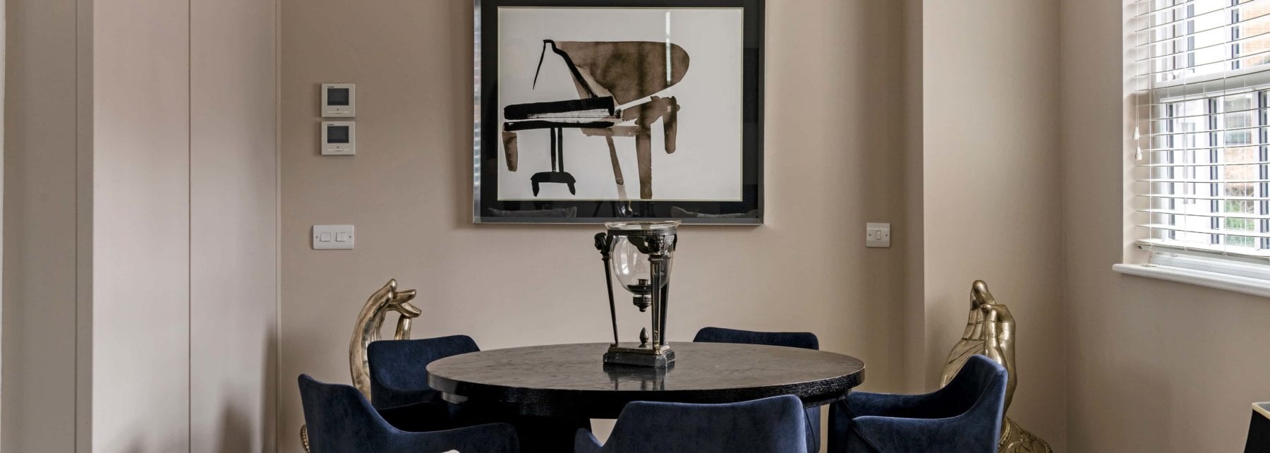 Elegant modern dining room with contemporary decor and stylish artwork, ideal for luxury property sale or leasing.