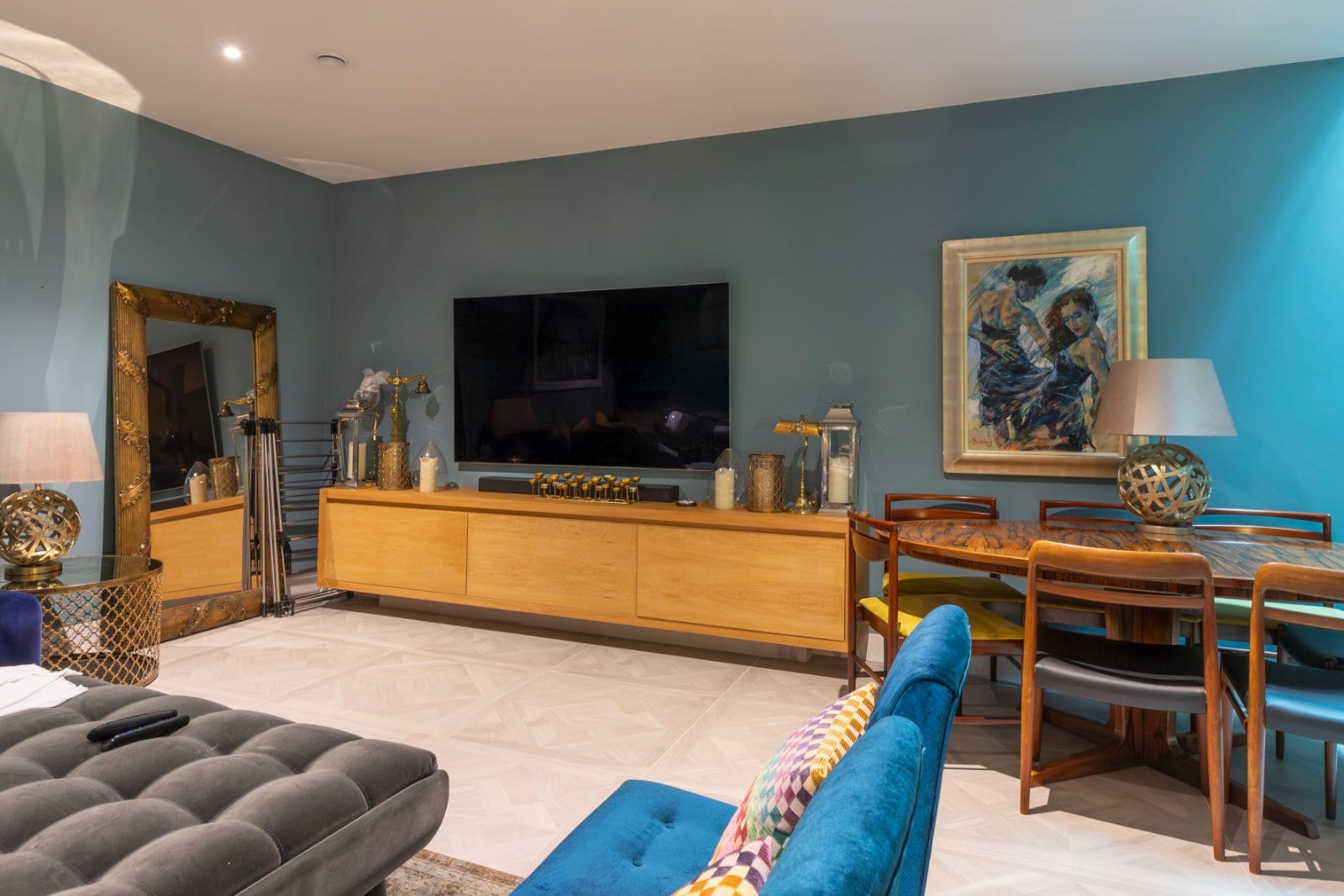 Stylish living room with teal walls, modern furniture, and elegant decor.