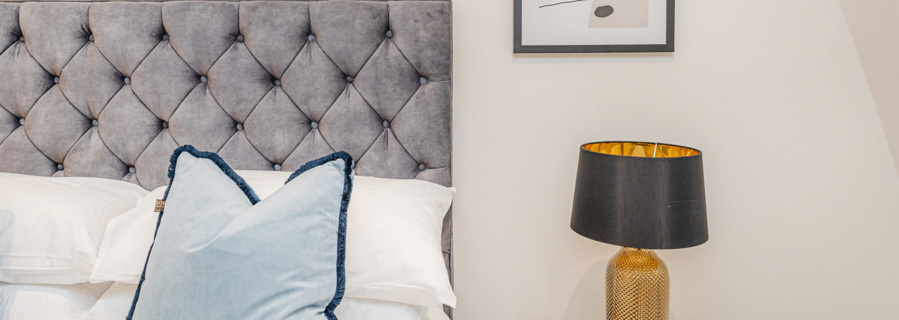 Luxurious hotel bedroom with velvet headboard and elegant decor in London.