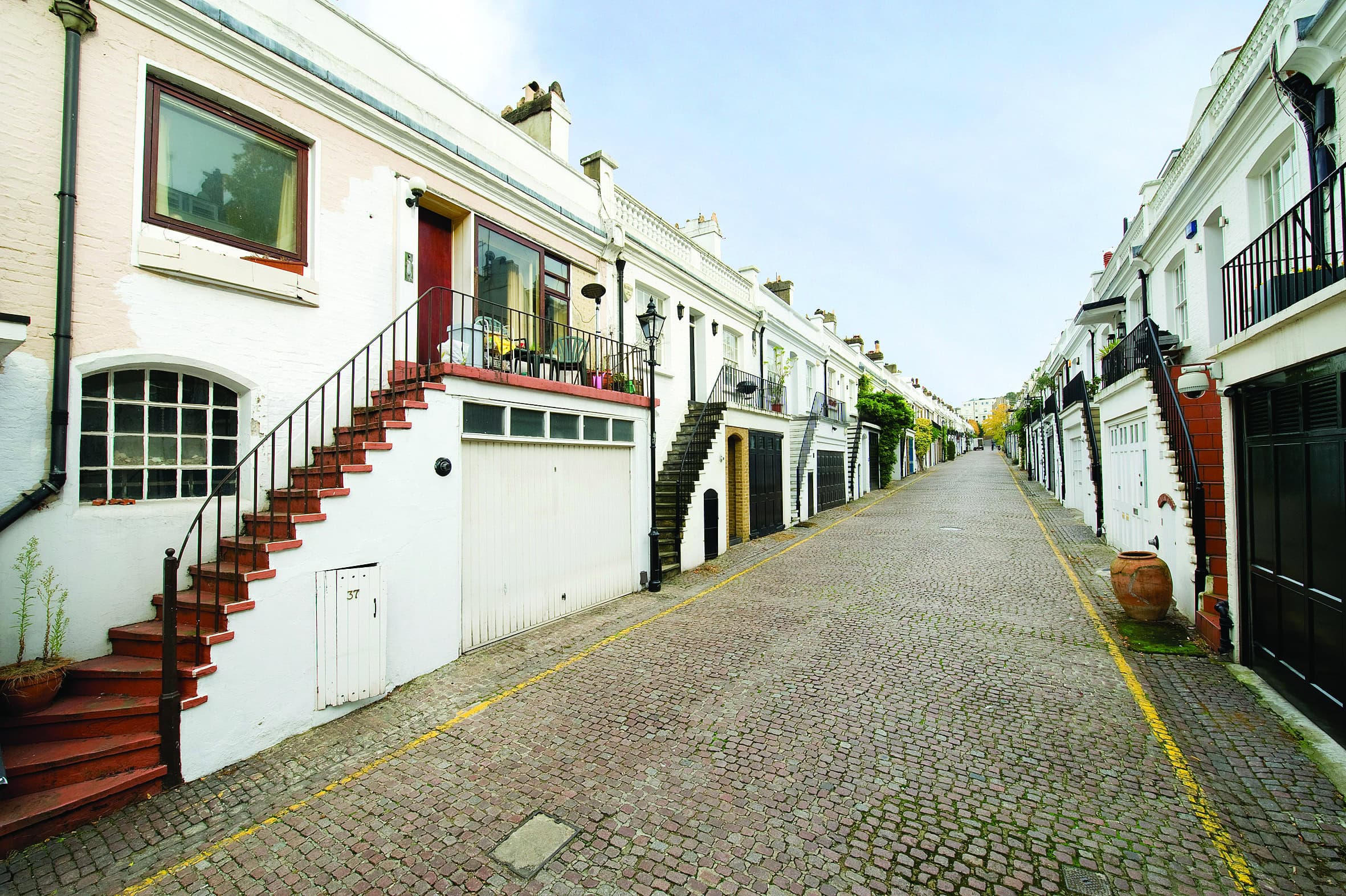 Picturesque white terraced houses on a cobbled street in London Mews.