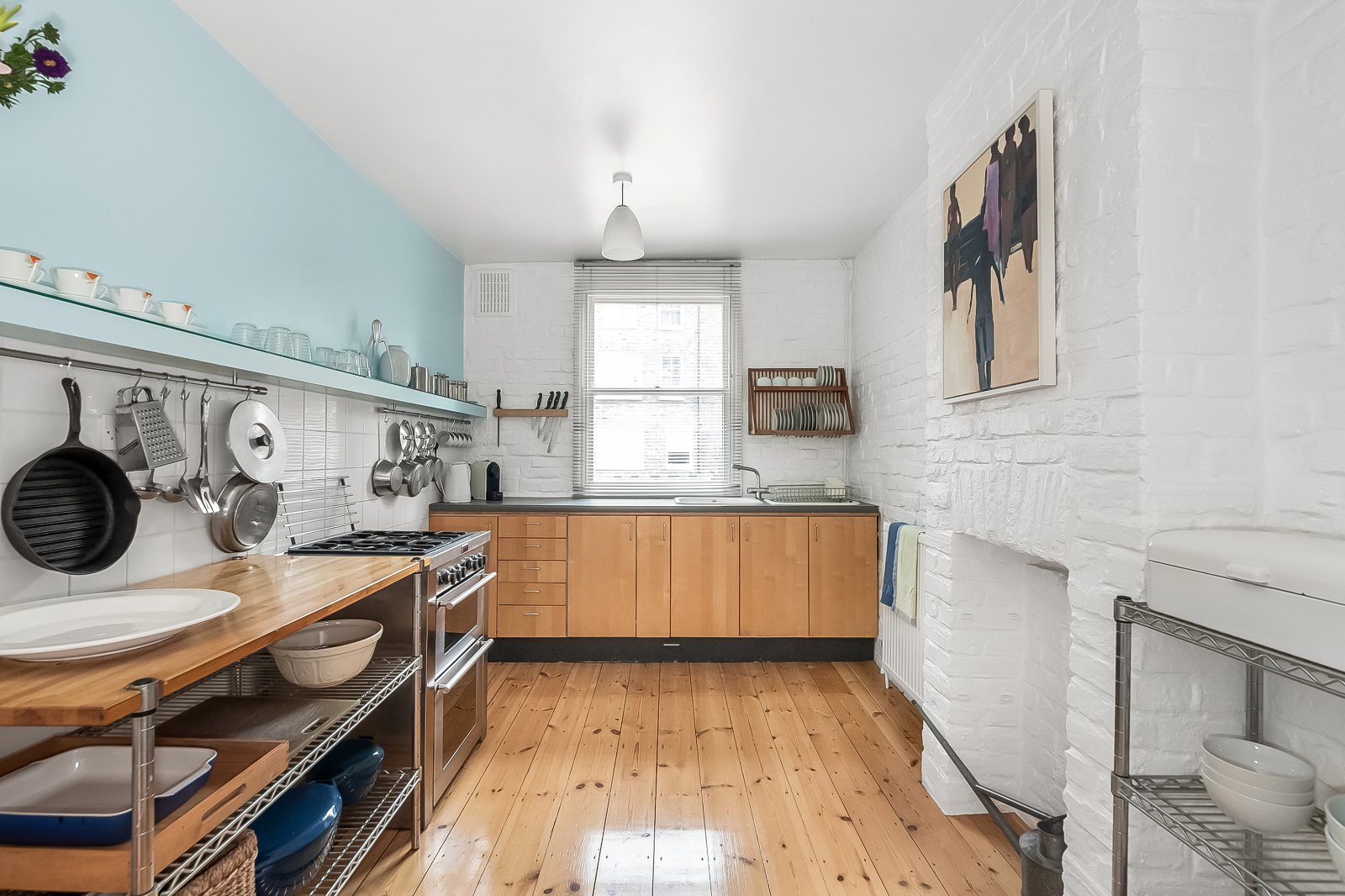 Bright modern kitchen with white brick walls, wooden cabinets, and open shelving for a stylish home cook space.