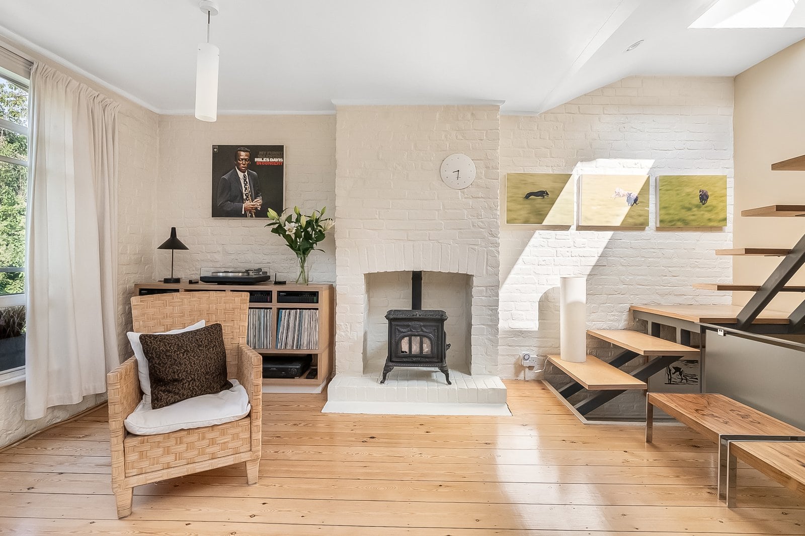 Cozy living room with white brick walls, wood flooring, and modern decor. Perfect for stylish London interior design.