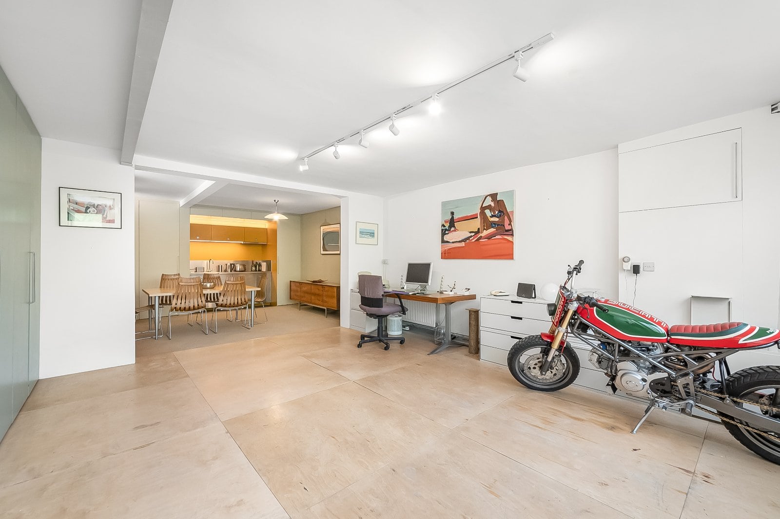 Modern interior living space with a classic motorcycle and contemporary furnishings, ideal for luxury property marketing.