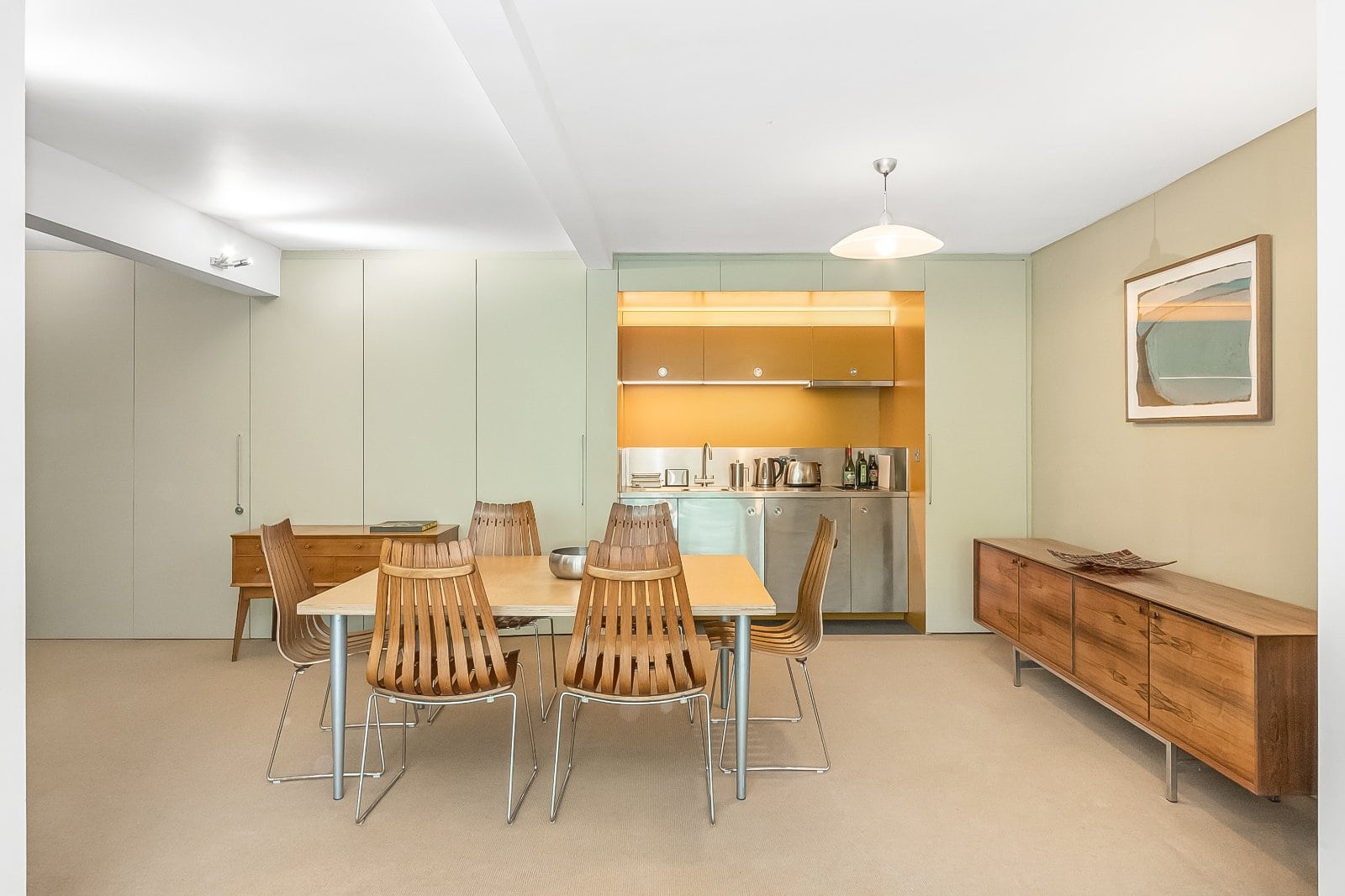 Contemporary open-plan kitchen and dining area featuring minimalist design and wooden furniture.