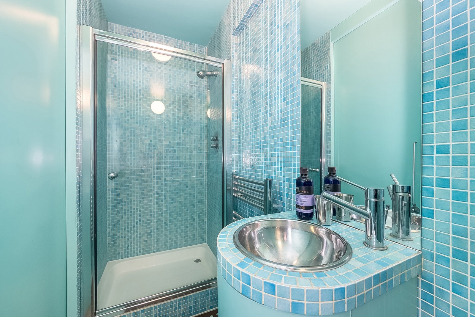 Shower room with blue mosaic tiles and modern fixtures.
