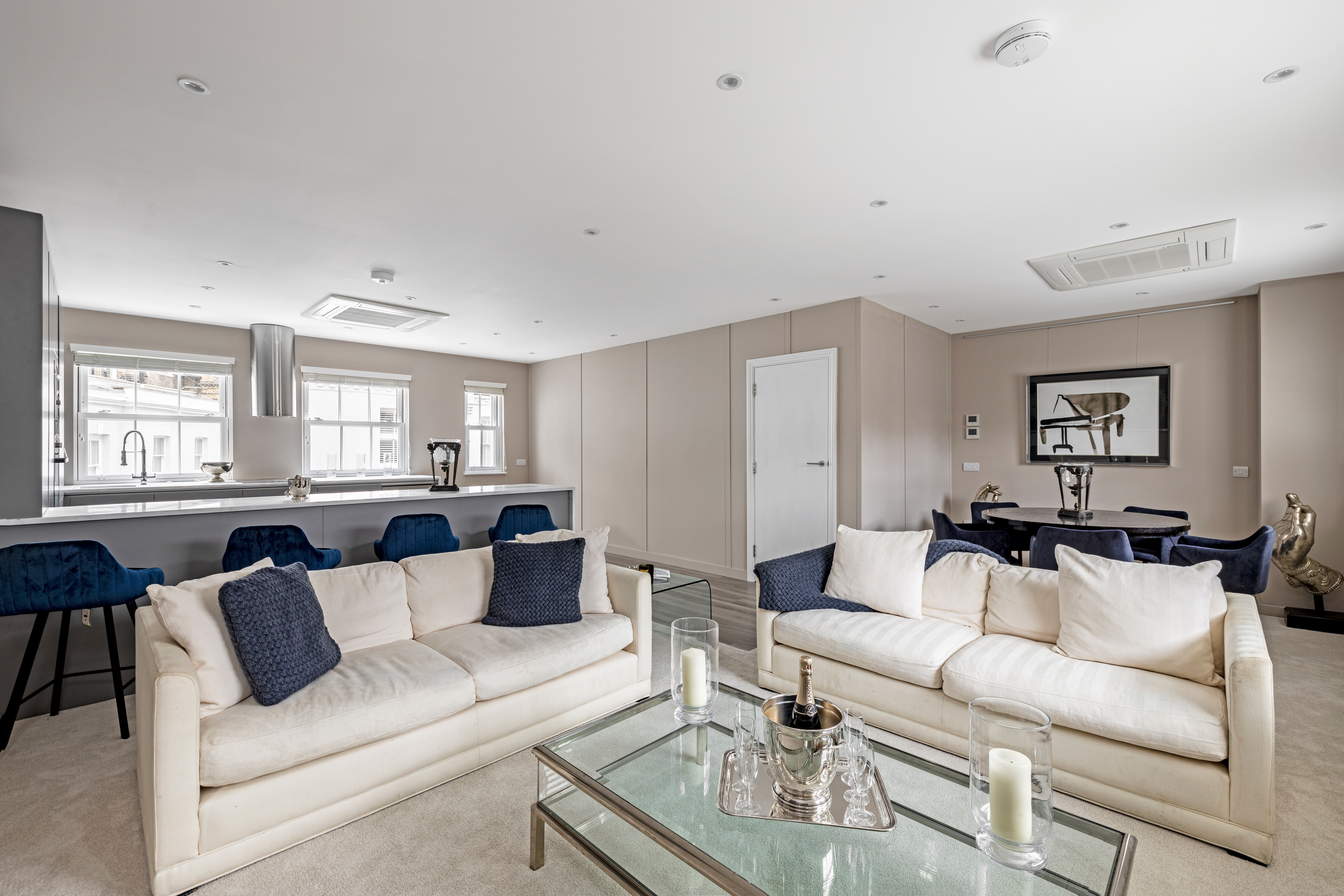 A living room with cream sofas in a mews property