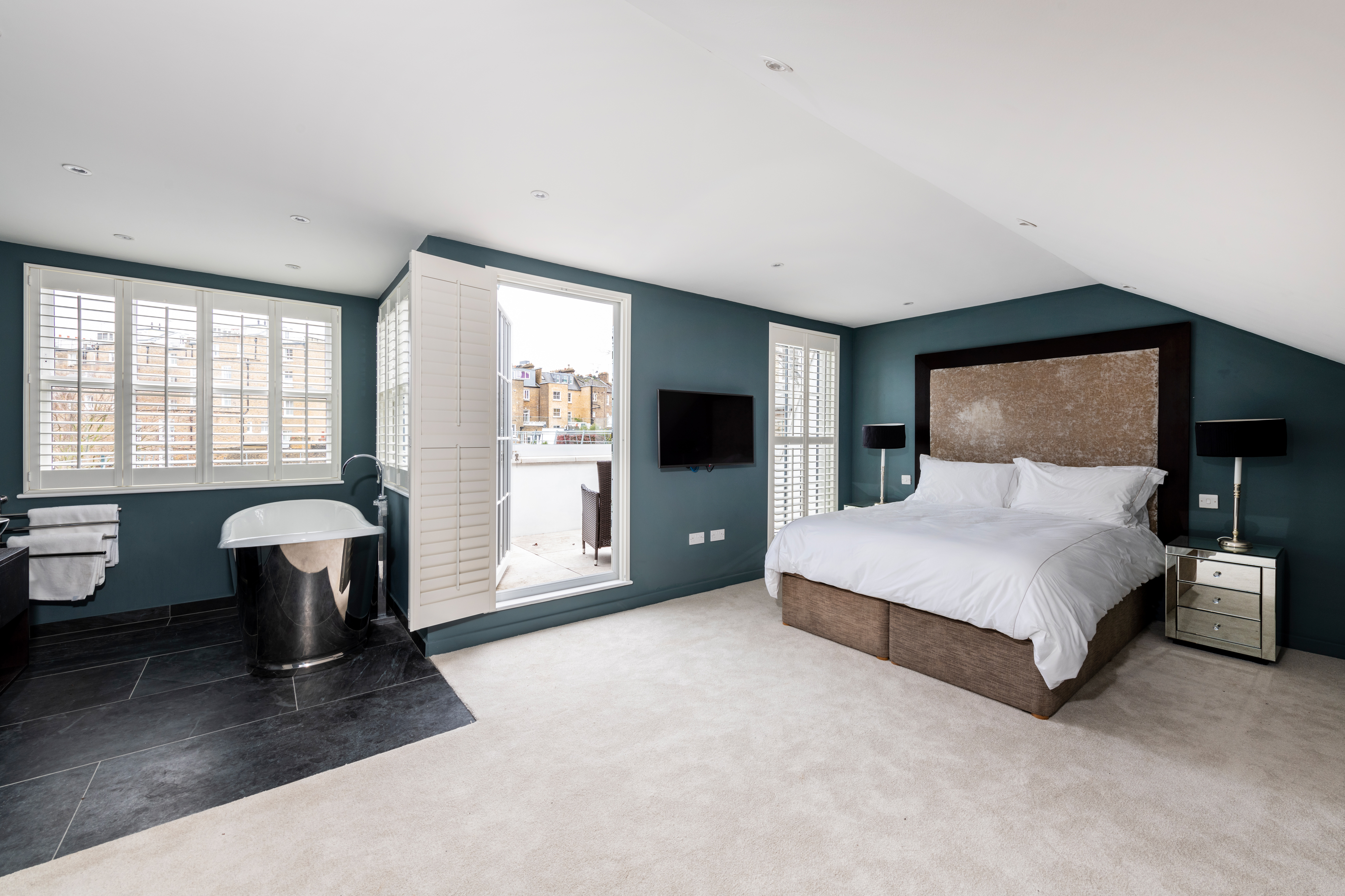 Large bedroom with freestanding bath and open plan terrace