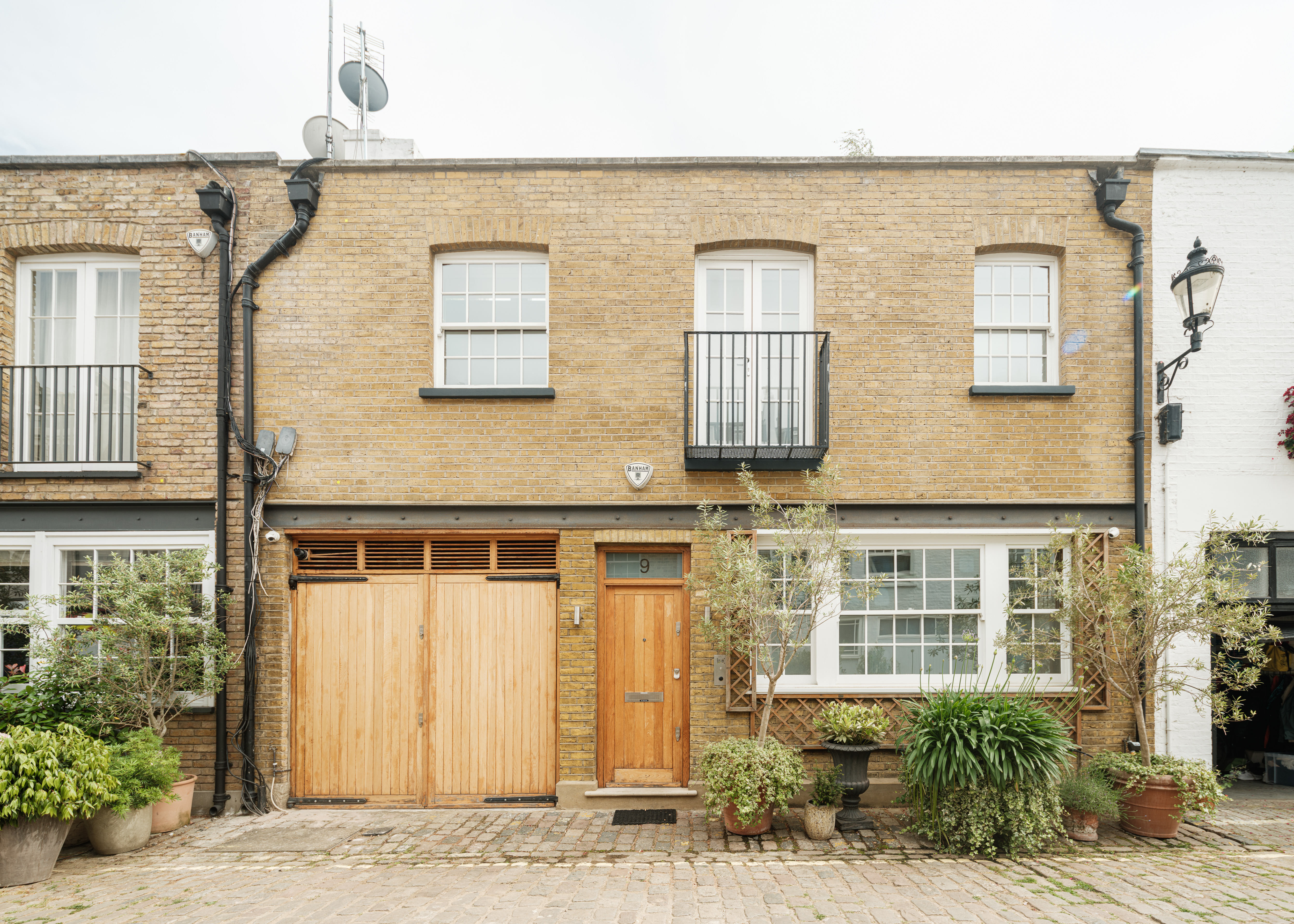 a mews property with a brown door and garage