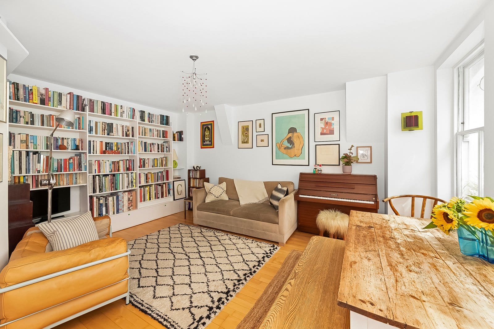 Cozy living room with built-in bookshelf, beige sofa, and vintage decor in a bright apartment.