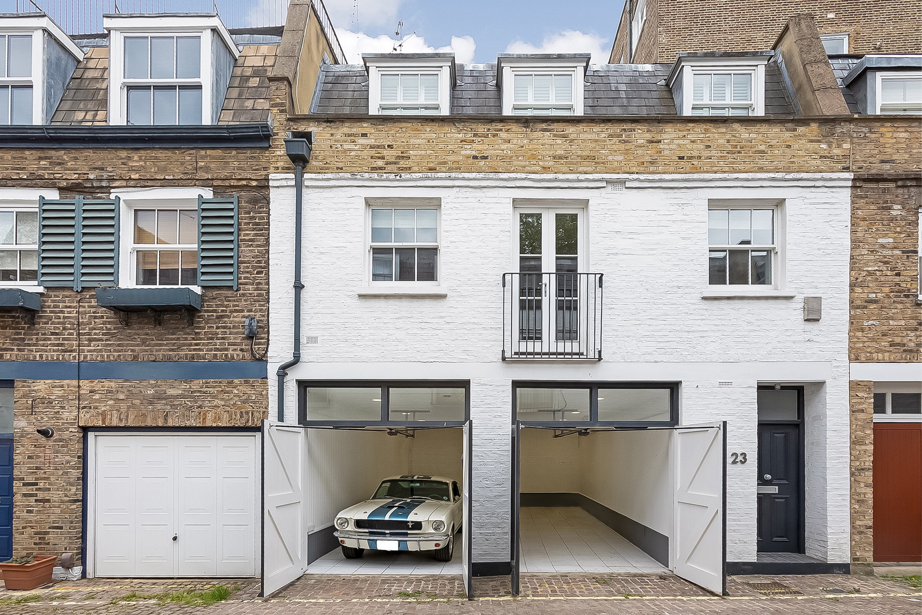 A Mews House With A Garage And Car Inside The Garage