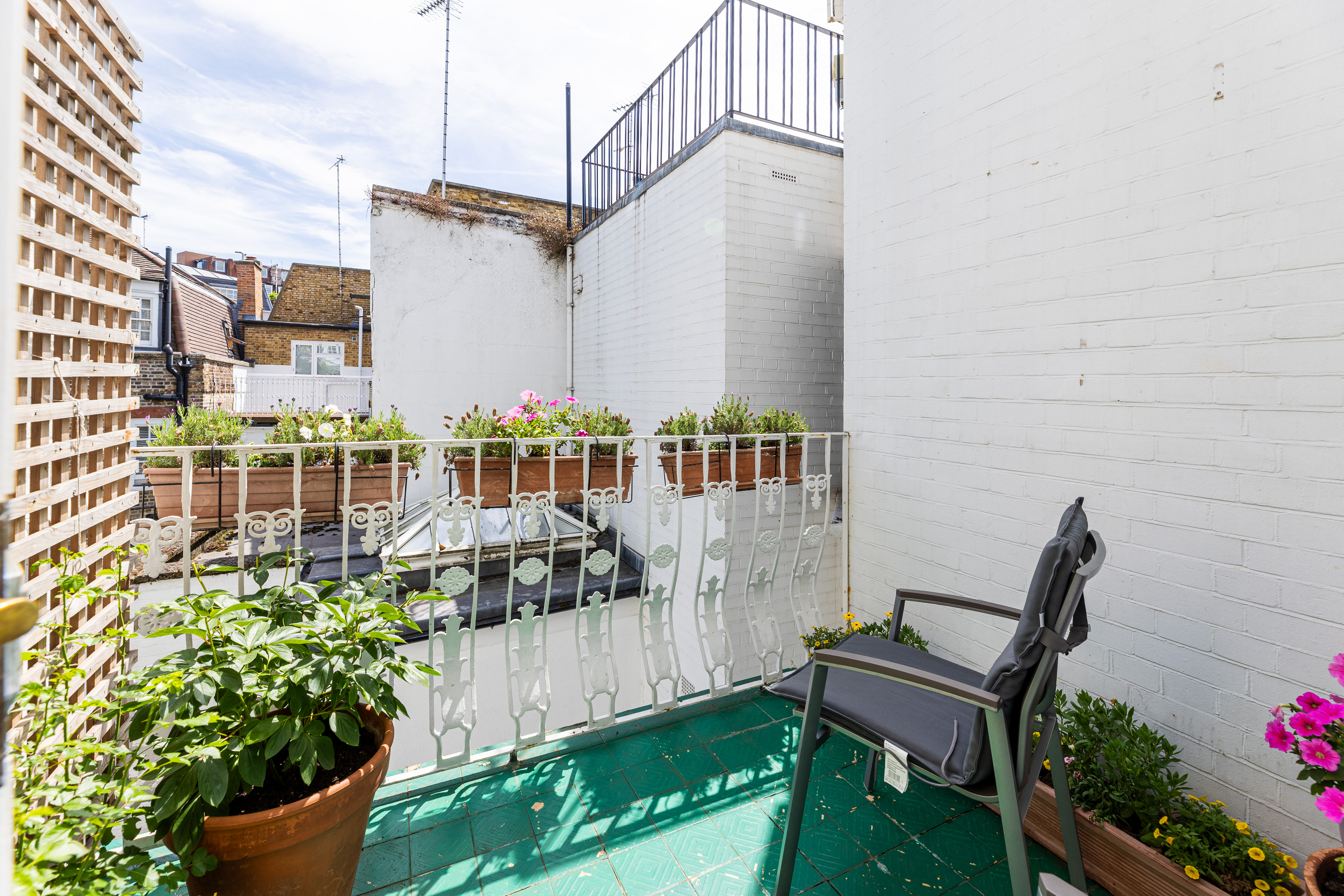 A balcony overlooking a courtyard of a property to rent with a plant