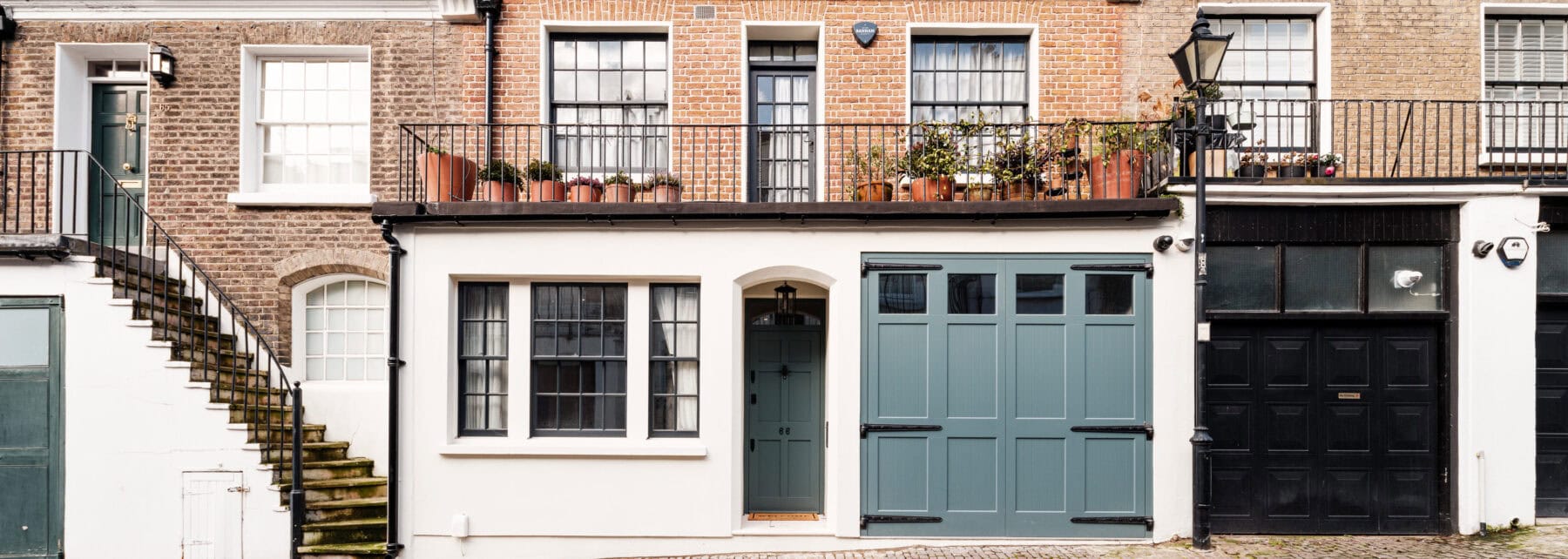 Charming Georgian townhouses with colourful doors and classic brick facades in London.