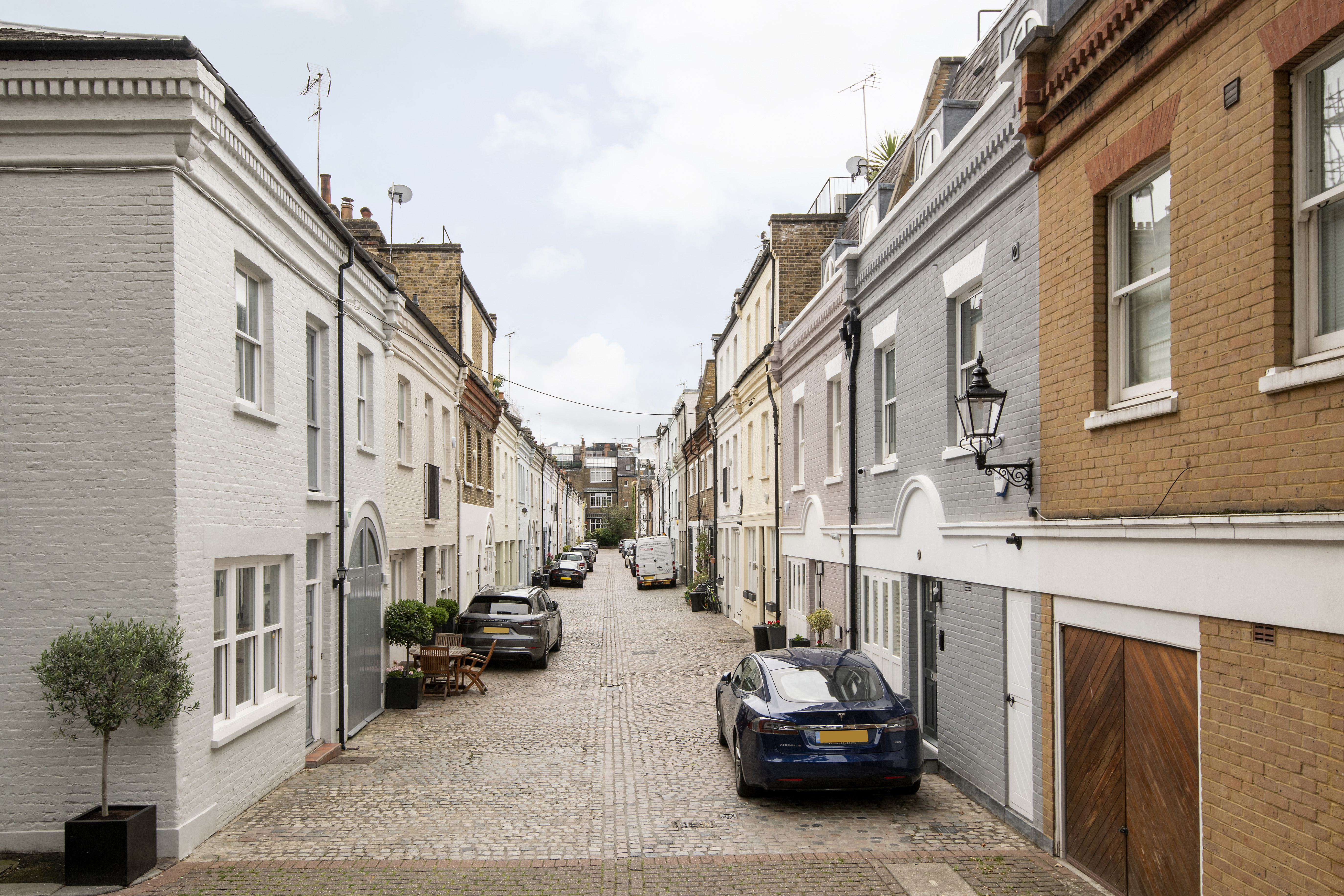 A mews street in London with two parked cars