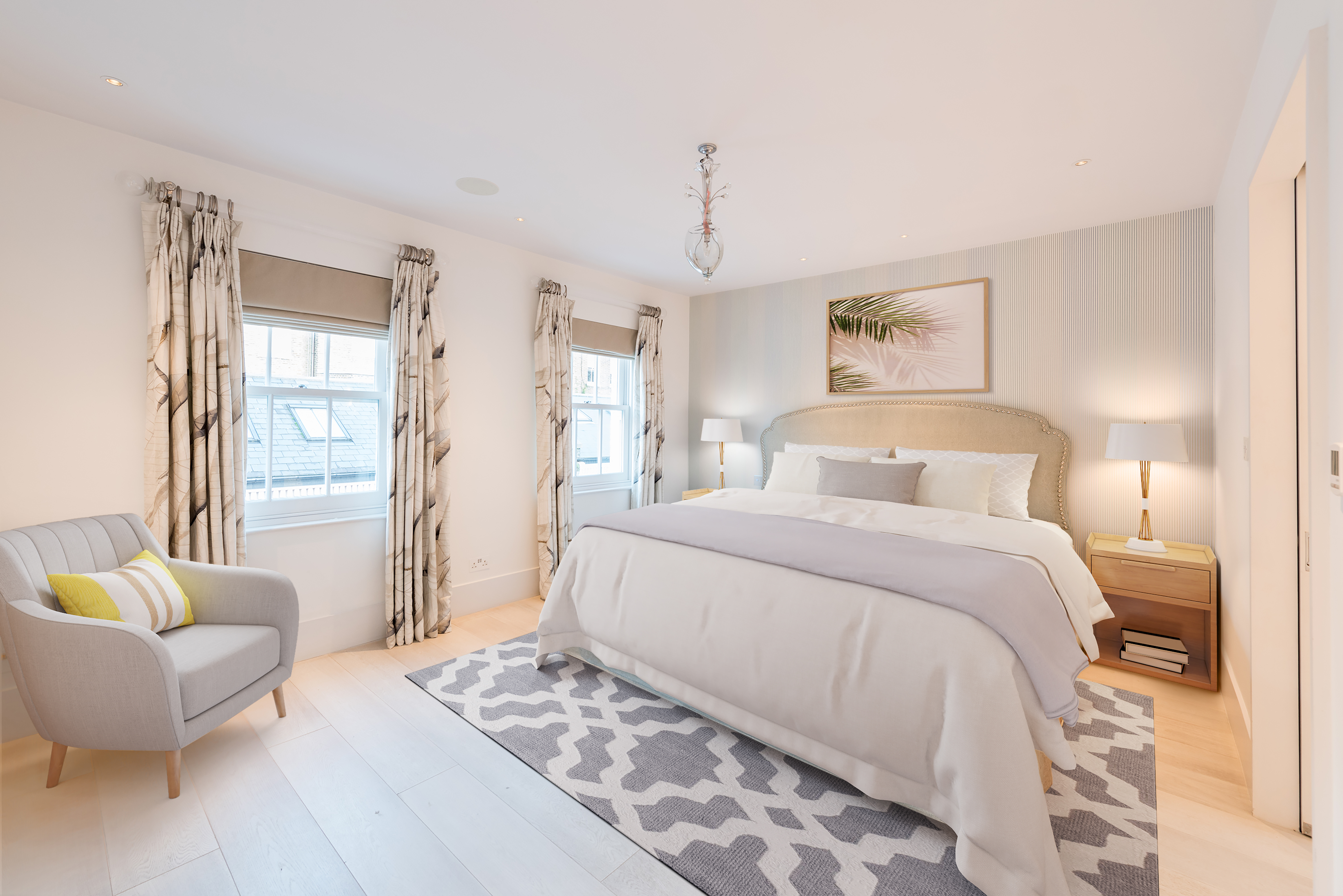 A double bedroom within a mews property in London with drapes and a chair in the room