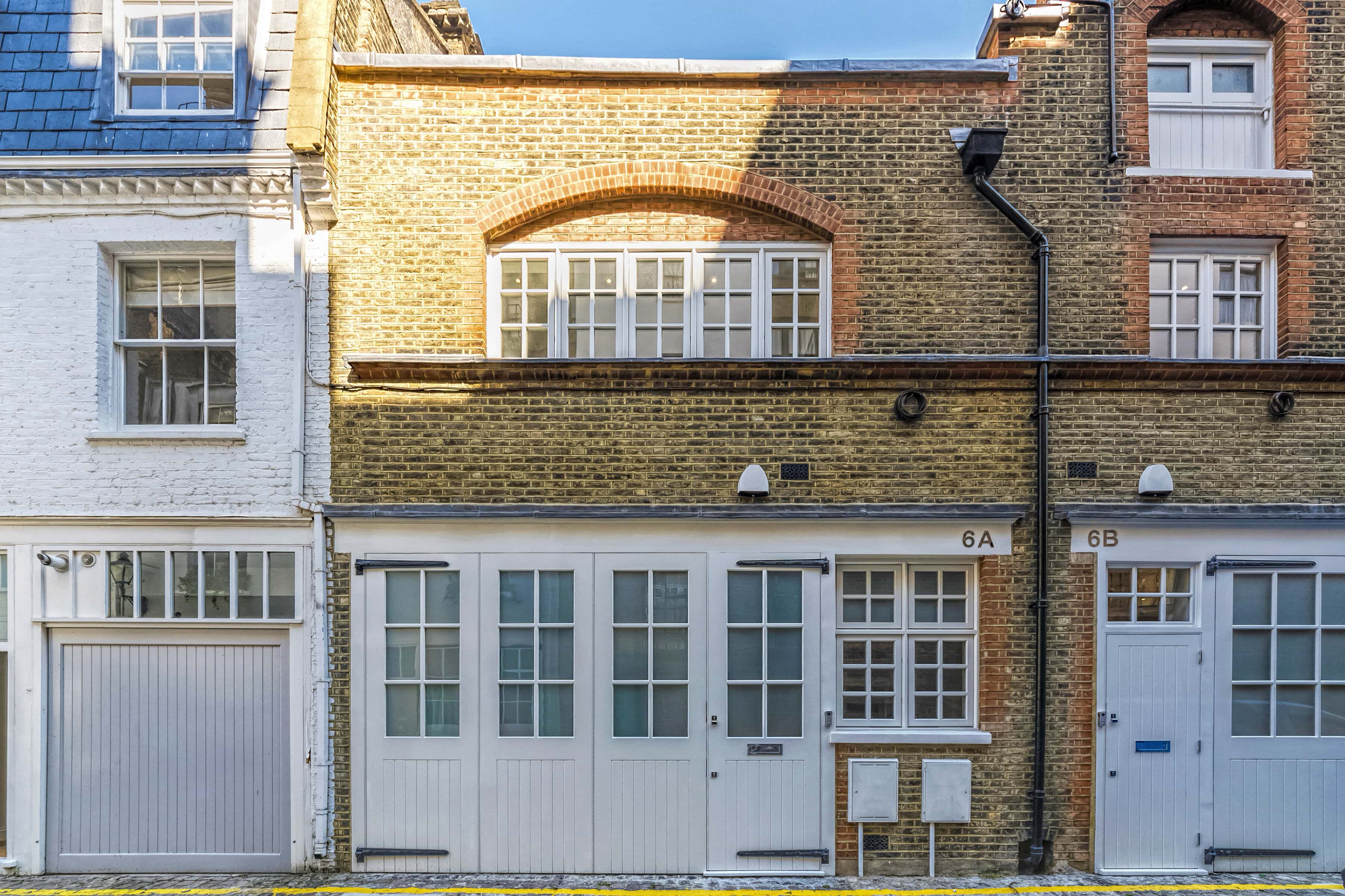 A mews property with brickwork and a white door