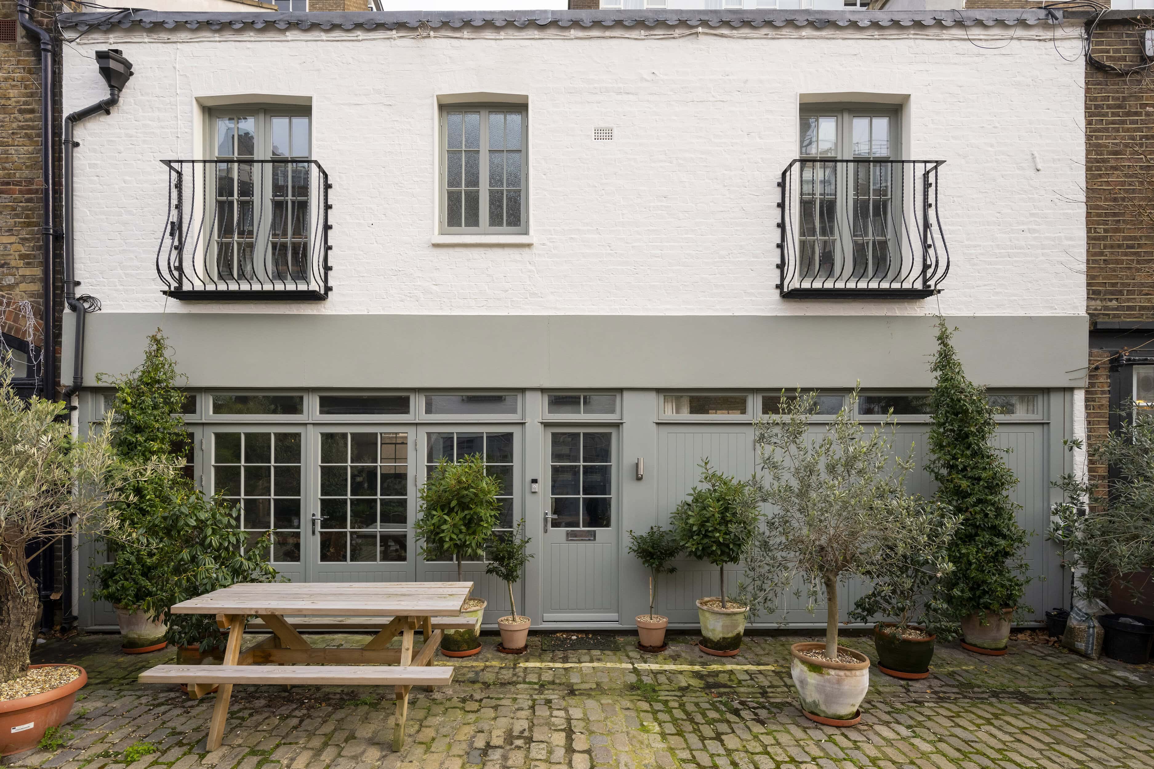 A mews property with a bench and plants outside