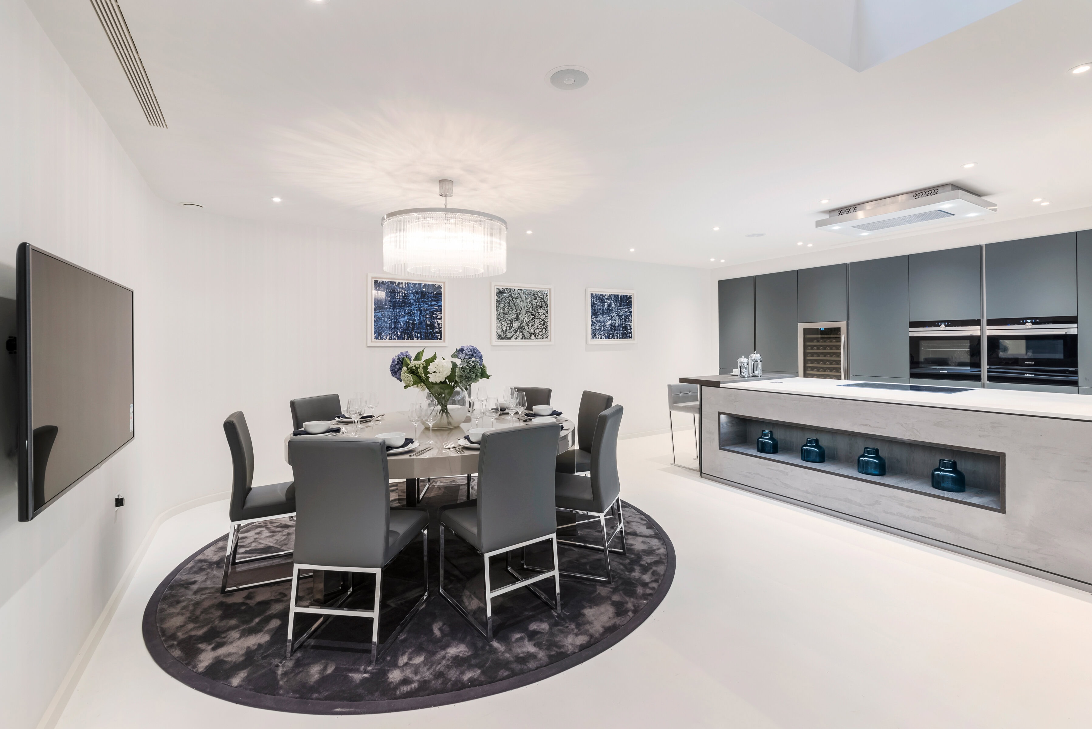 An open-plan kitchen with a dining table with chairs