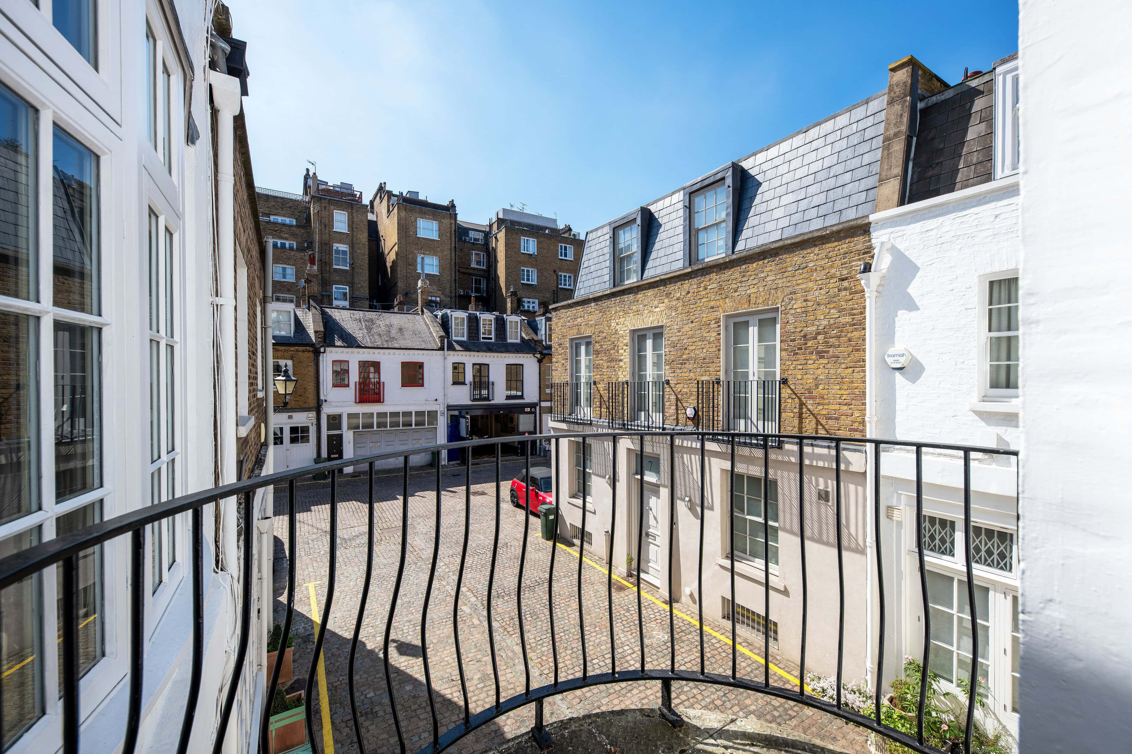 A balcony overlooking a mews street from a mews property
