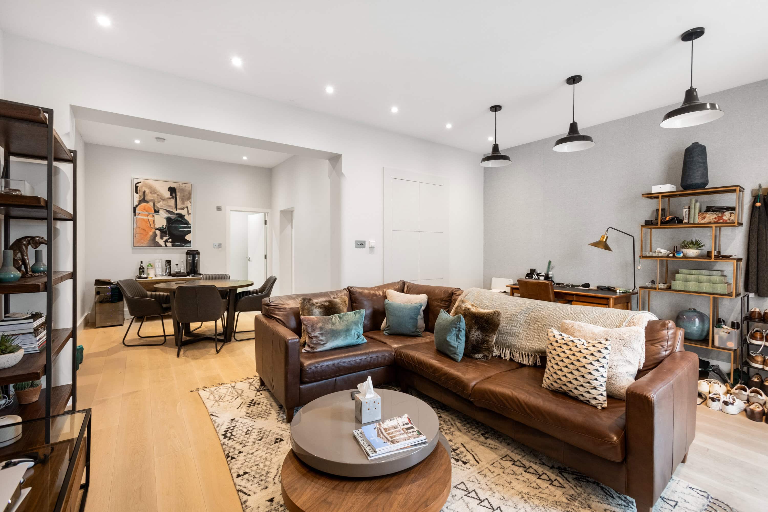 The inside of a mews house with a brown leather sofa with cushions