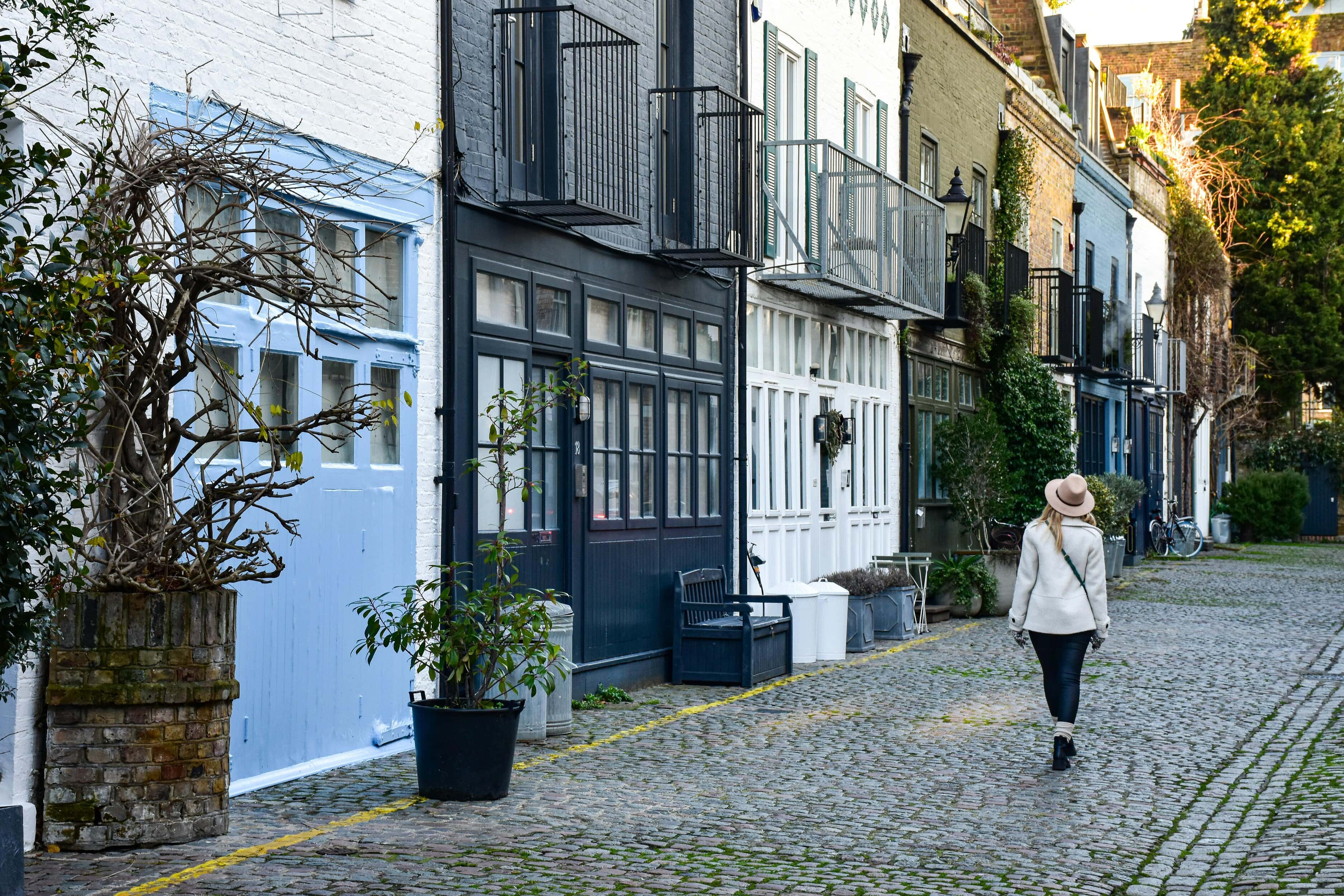 A woman walking down a mews street