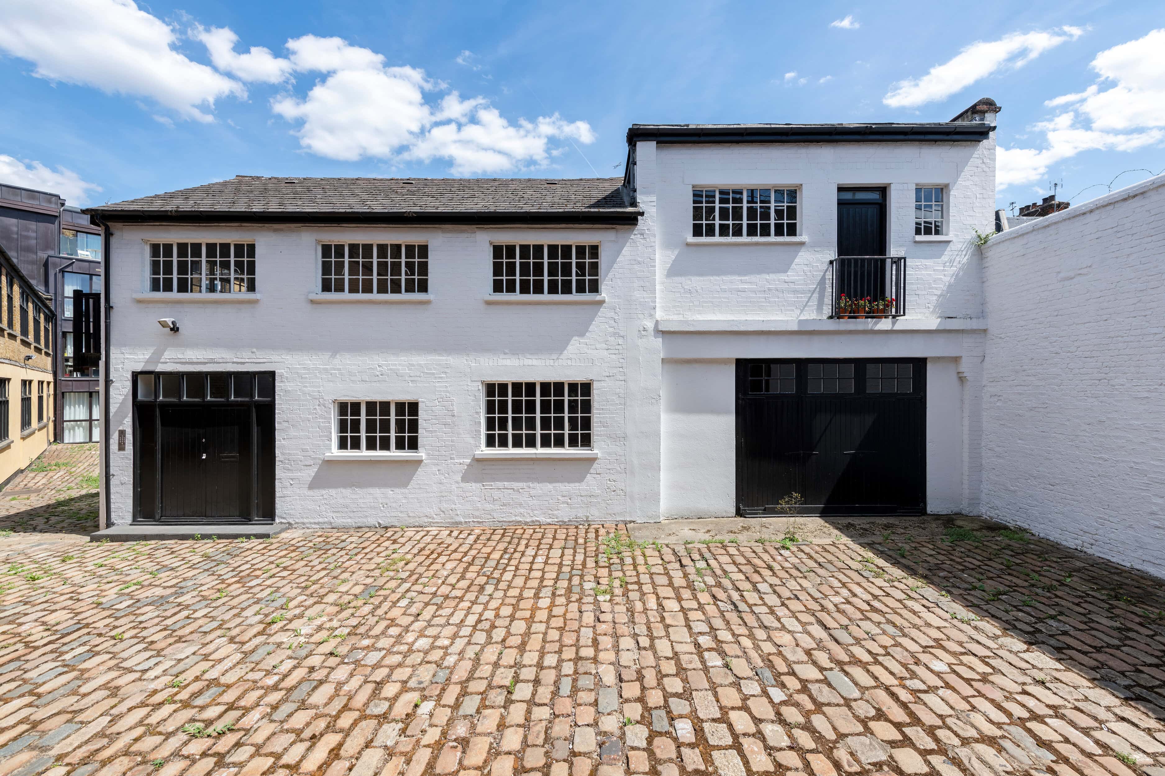 A white mews house with black doors