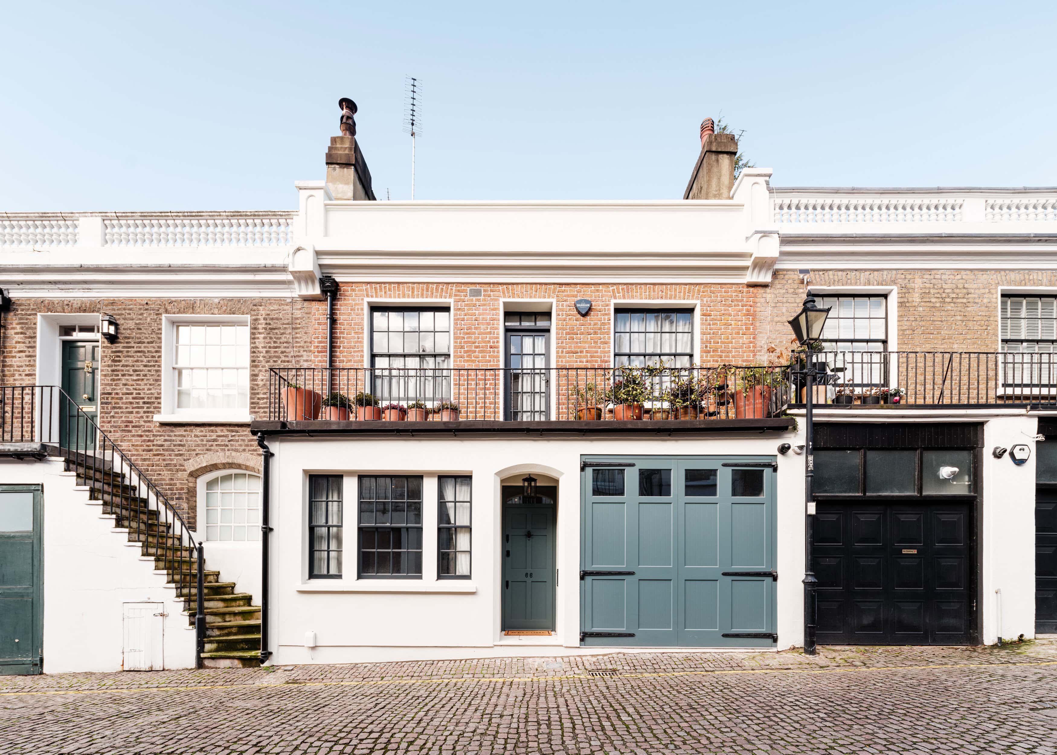 A beautiful mews house with a blue garage