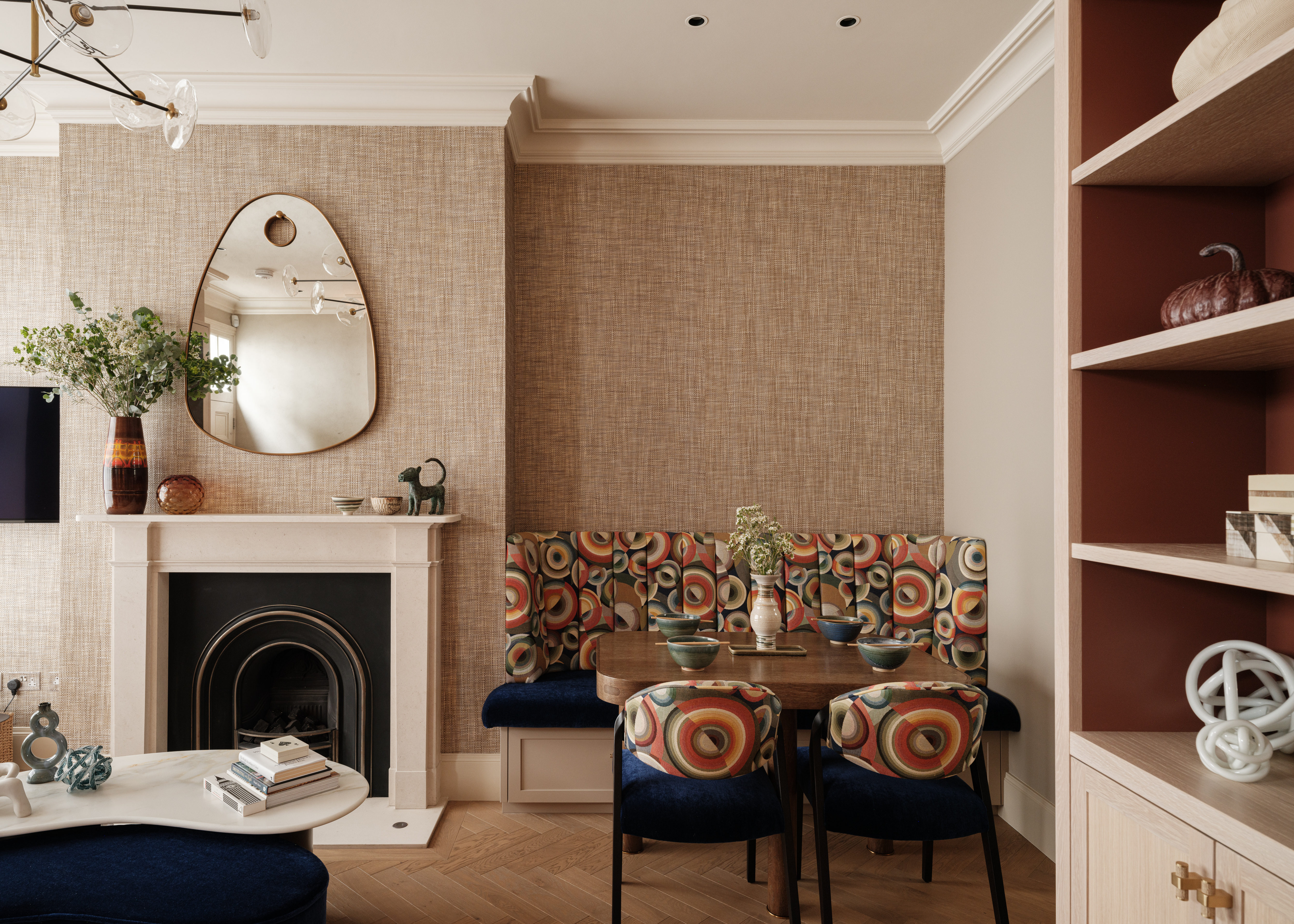 The living room in a mews house with a fireplace and dining table and chairs