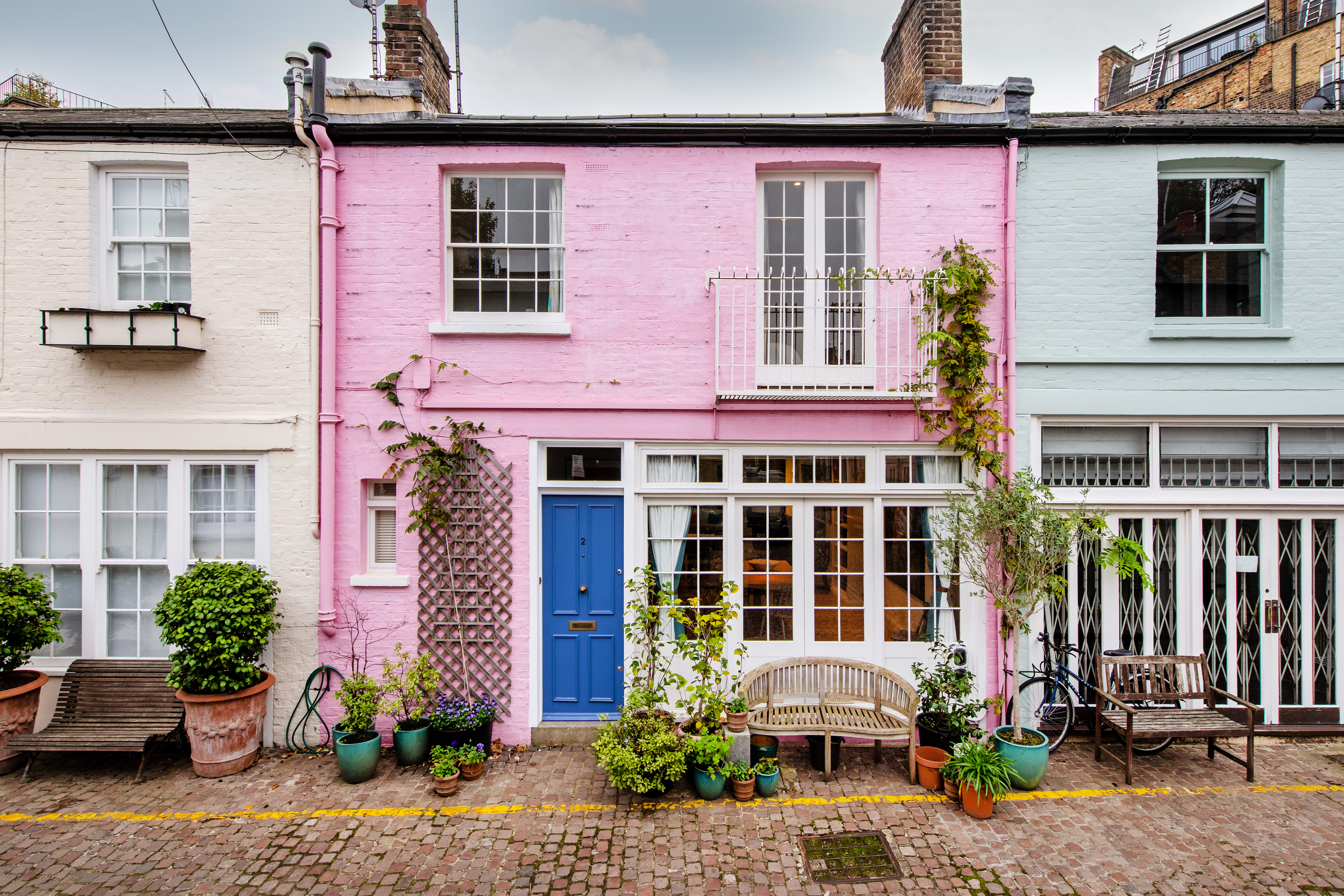 A pink mews house with flowers outside