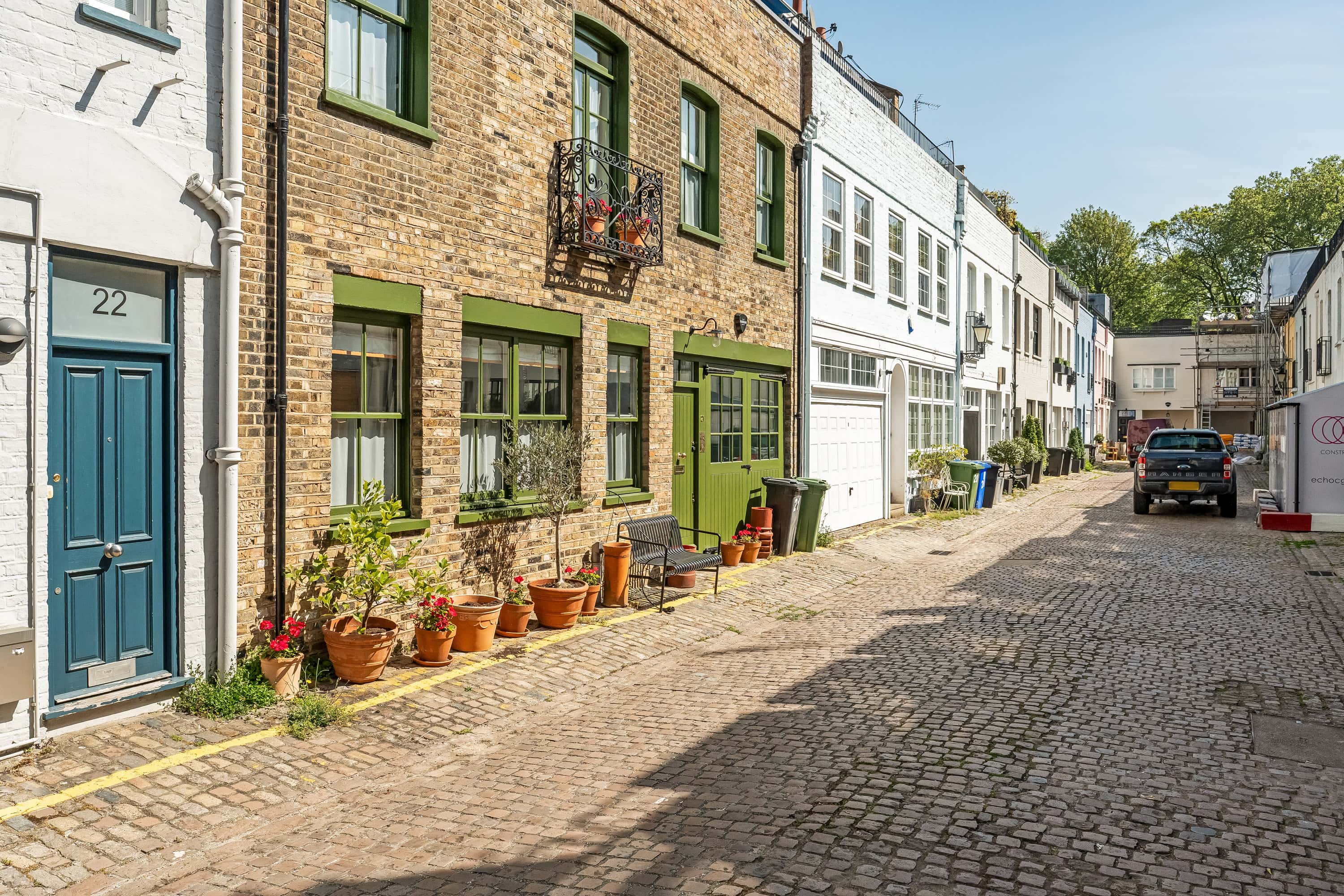 Mews houses in a a mews street with potted plants outside the front door