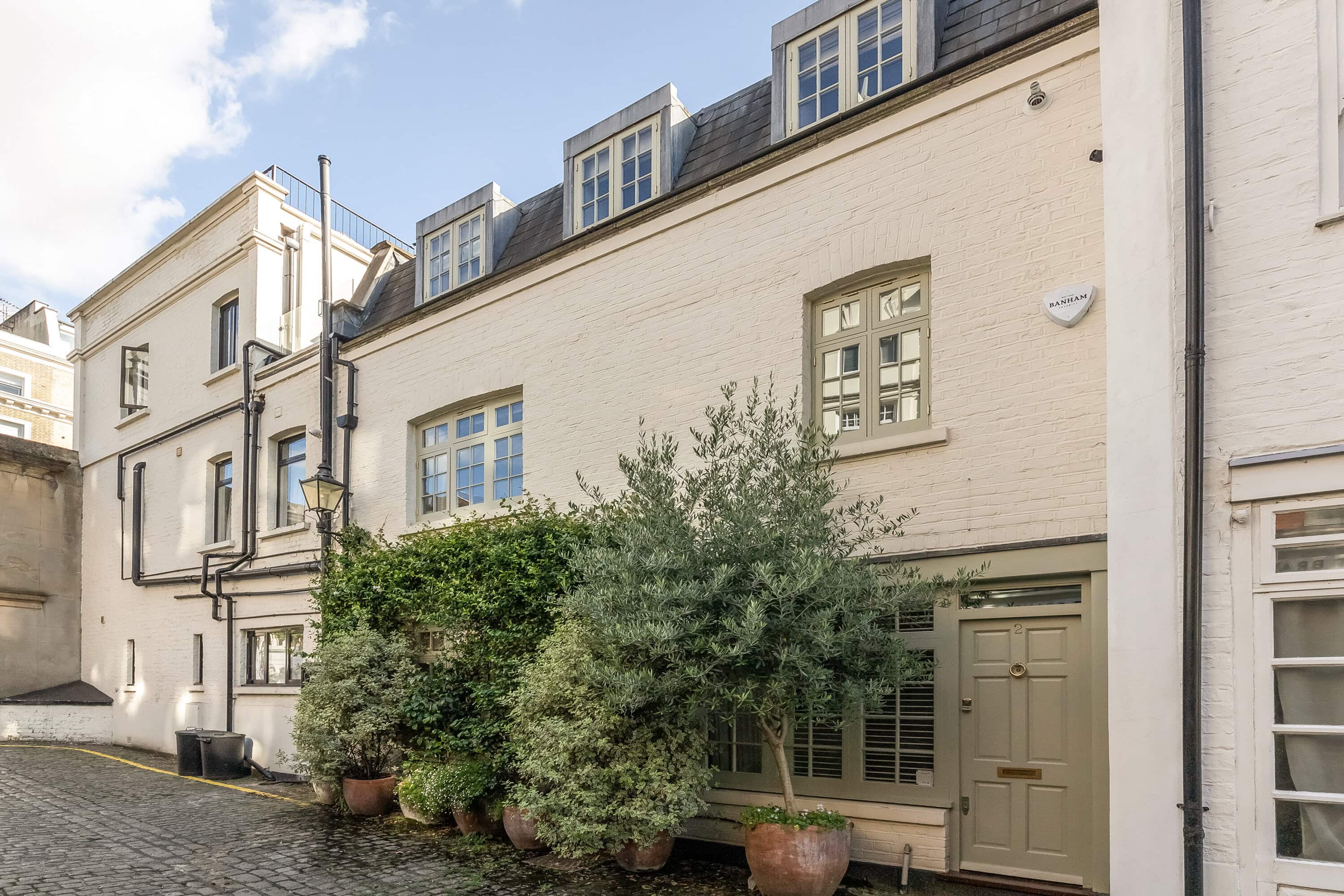 The front of a mews house to rent with plants outside the front door