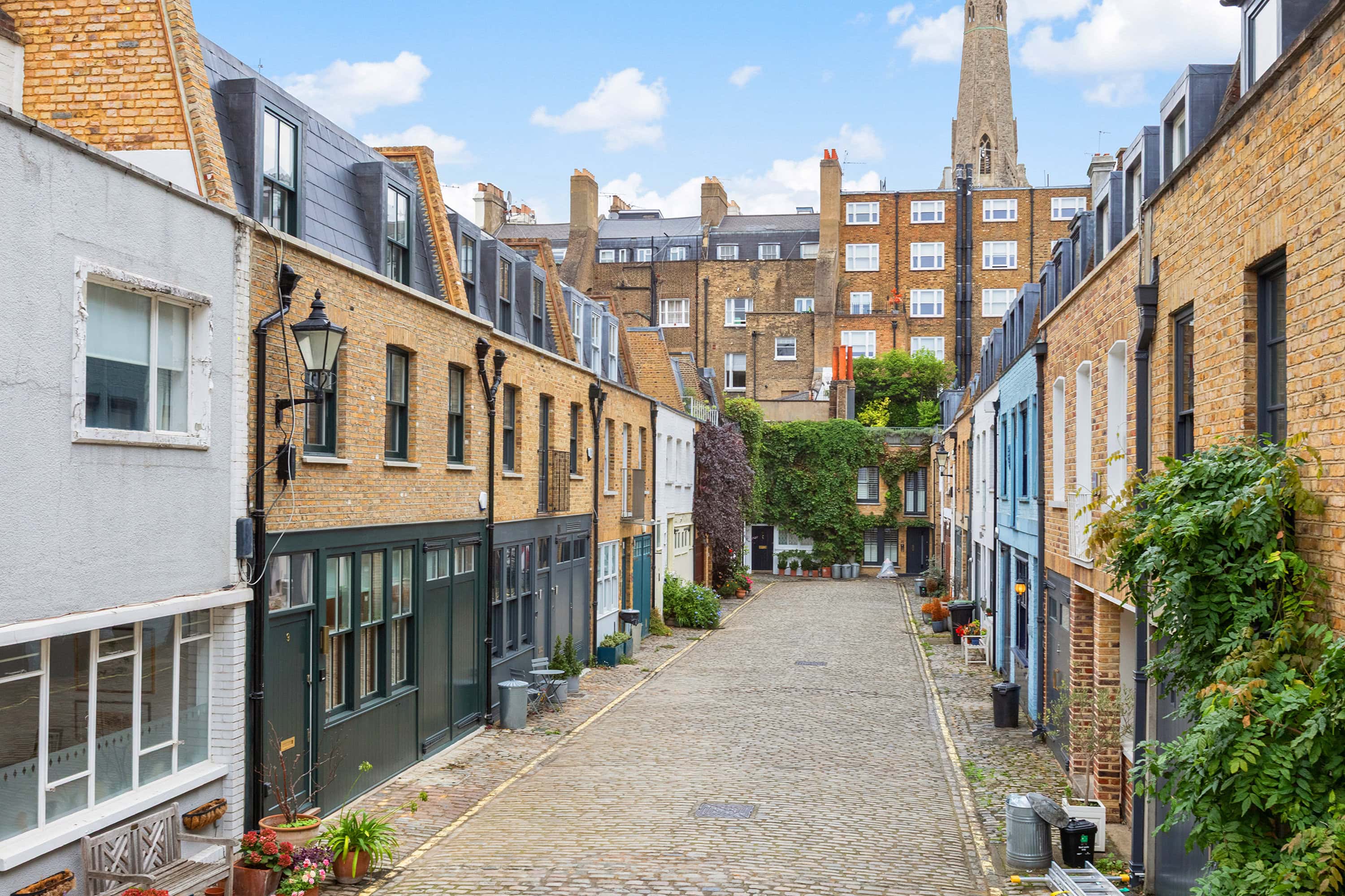A group of mews houses with a church in the background