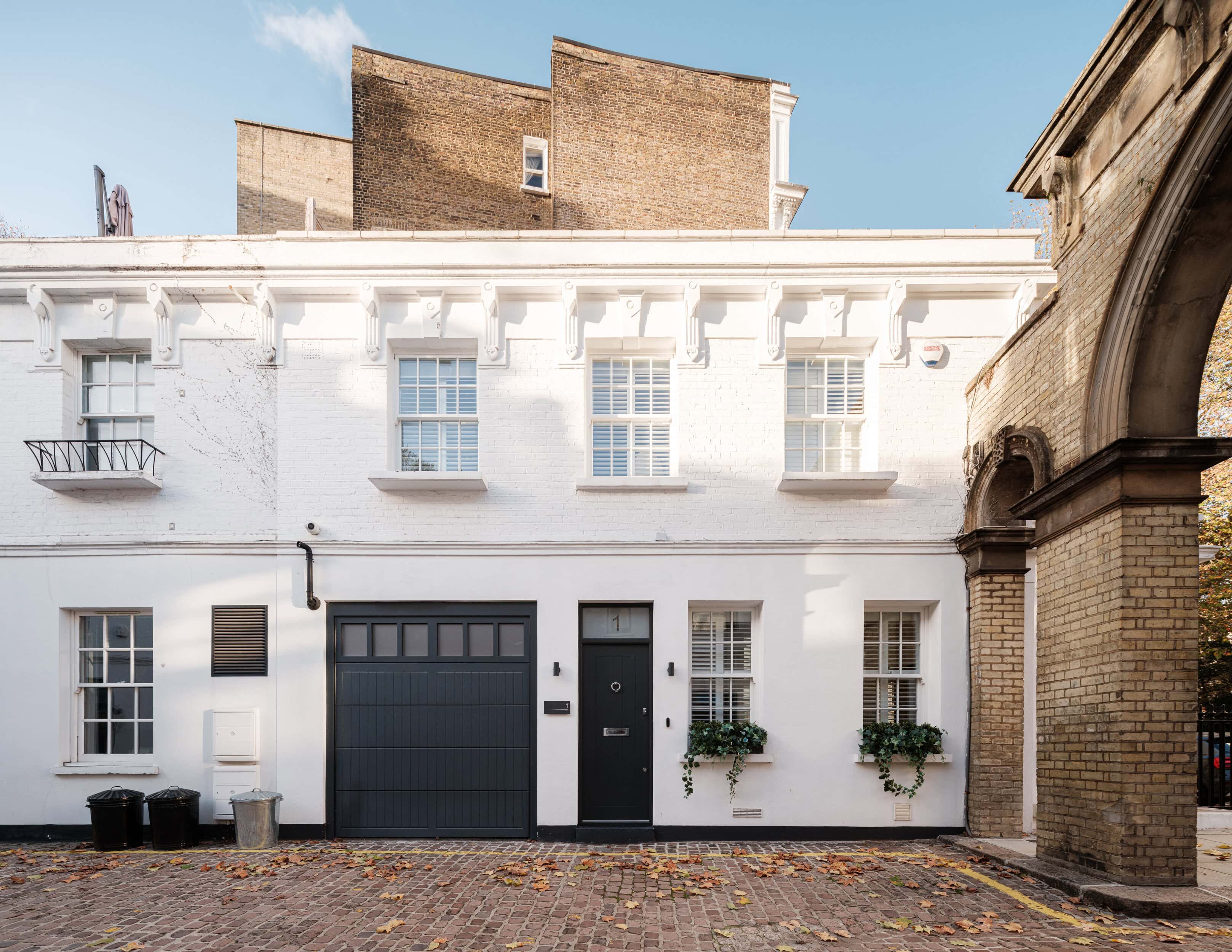A white mews property with a black door