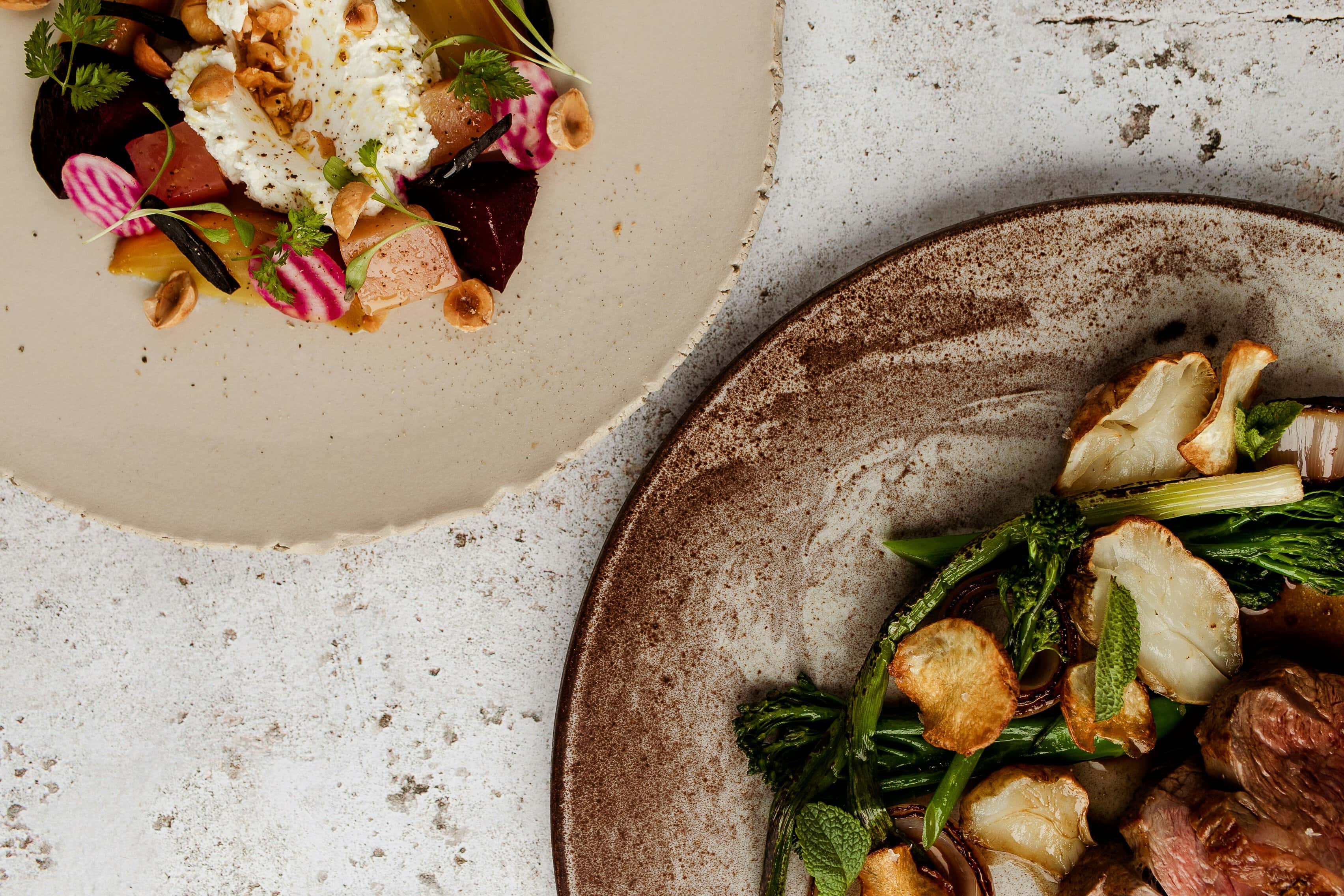 Elegant gourmet dishes on rustic plates at a restaurant.